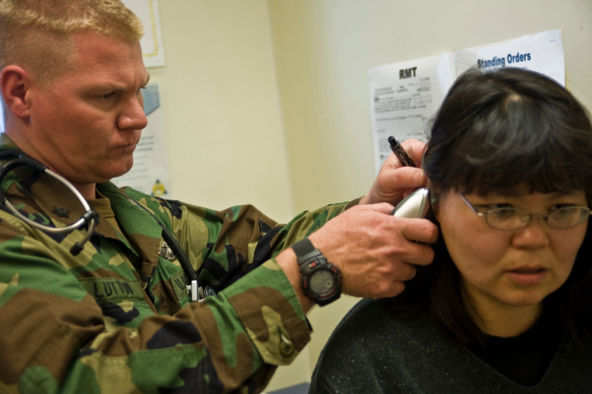 Navy Hospital Corpsman 2nd Class Chris Lutton of Simi Valley, Calif., attached to the 4th Marine Division, Weapons Company 223, checks Martha Wasky for signs of an ear infection during her health physical in Mountain Village, Alaska, on March 11, 2009. A joint military medical team is deployed to Mountain Village in support of Operation Arctic Care. This year's Navy-led mission has teams in 14 villages in Alaska's Yukon-Kuskokwim Delta region providing medical, dental and veterinary support at no cost to Alaskan natives. (U.S. Air Force photo by Senior Airman Christopher Griffin)
