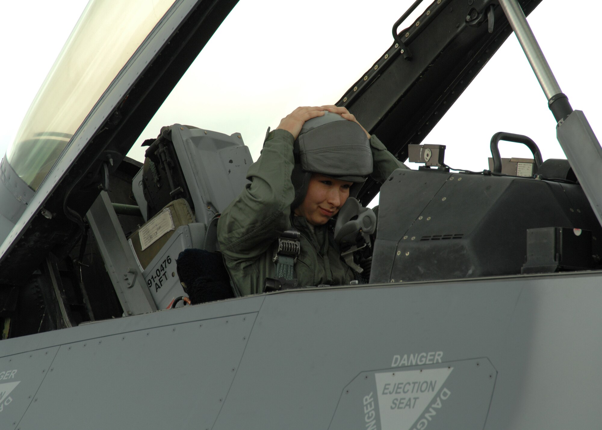 Senior Airman Heather Maldonado of the 355th Equipment Maintenance Squadron secures her helmet before taking an incentive flight in an F-16 Fighting Falcon during the annual Heritage Flight Conference here March 6. Airman Maldonado, the 355th Fighter Wing 2008 Airman of the Year, said the ride was "definitely a once-in-a-lifetime experience." (U.S. Air Force photo/Staff Sgt. Jake Richmond)