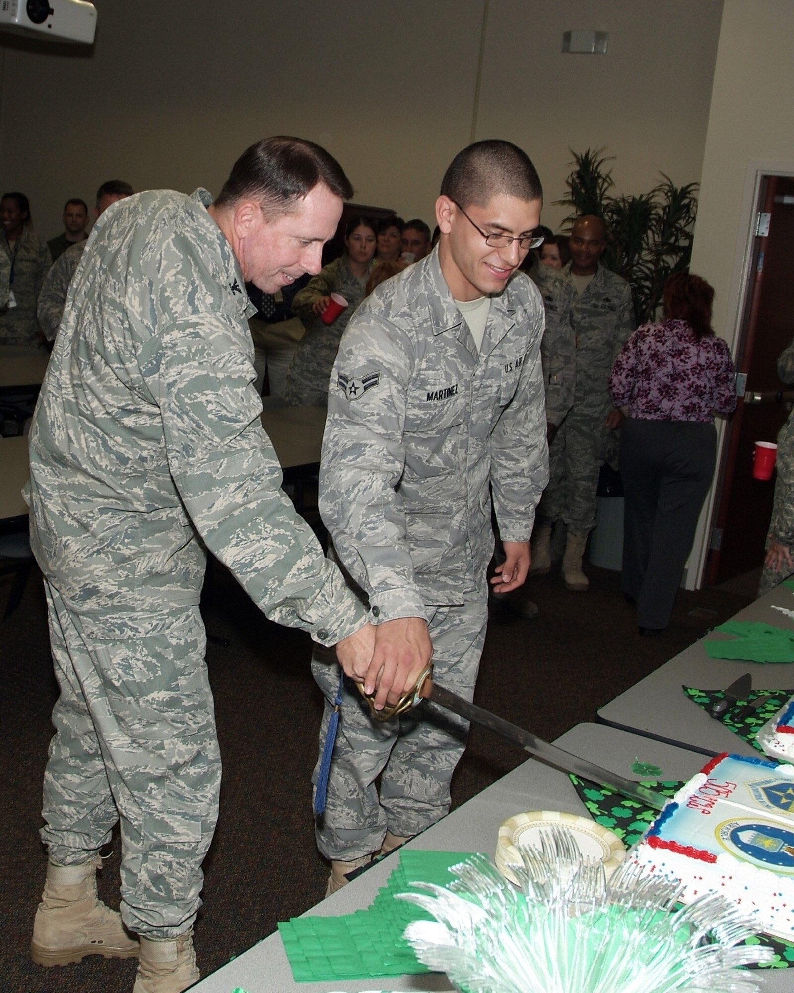 Col. Jack Shanahan, commander of the 505th Command and Control Wing, cuts a birthday cake with Airman 1st Class Juan Martinez during the wing's fifth anniversary celebration March 12.