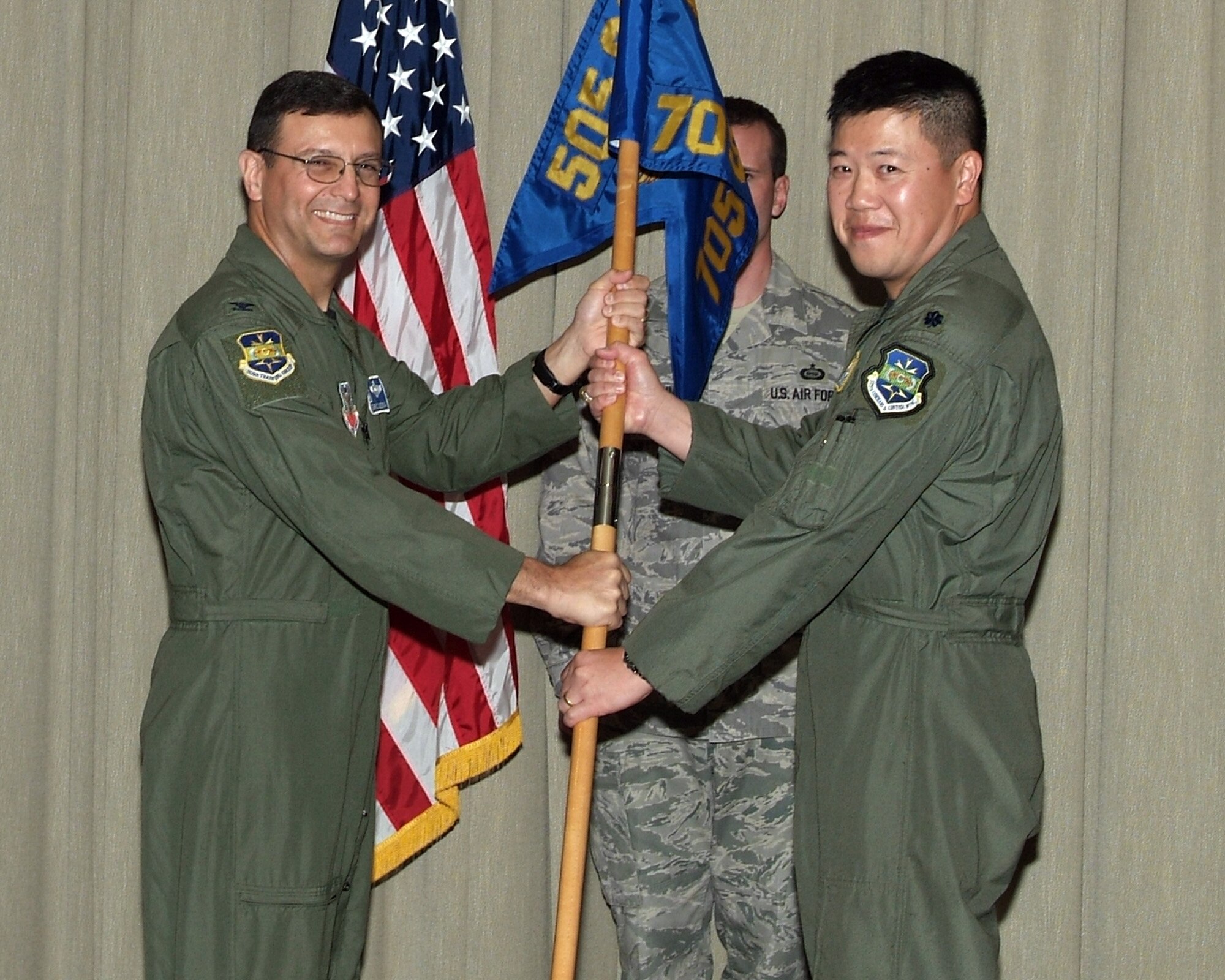 From left to right. Col. Christopher DiNenna, 505th Training Group commander, hands the 705th Training Squadron guidon to Lt. Col. Gregory Yuen, 705th Training Squadron commander
