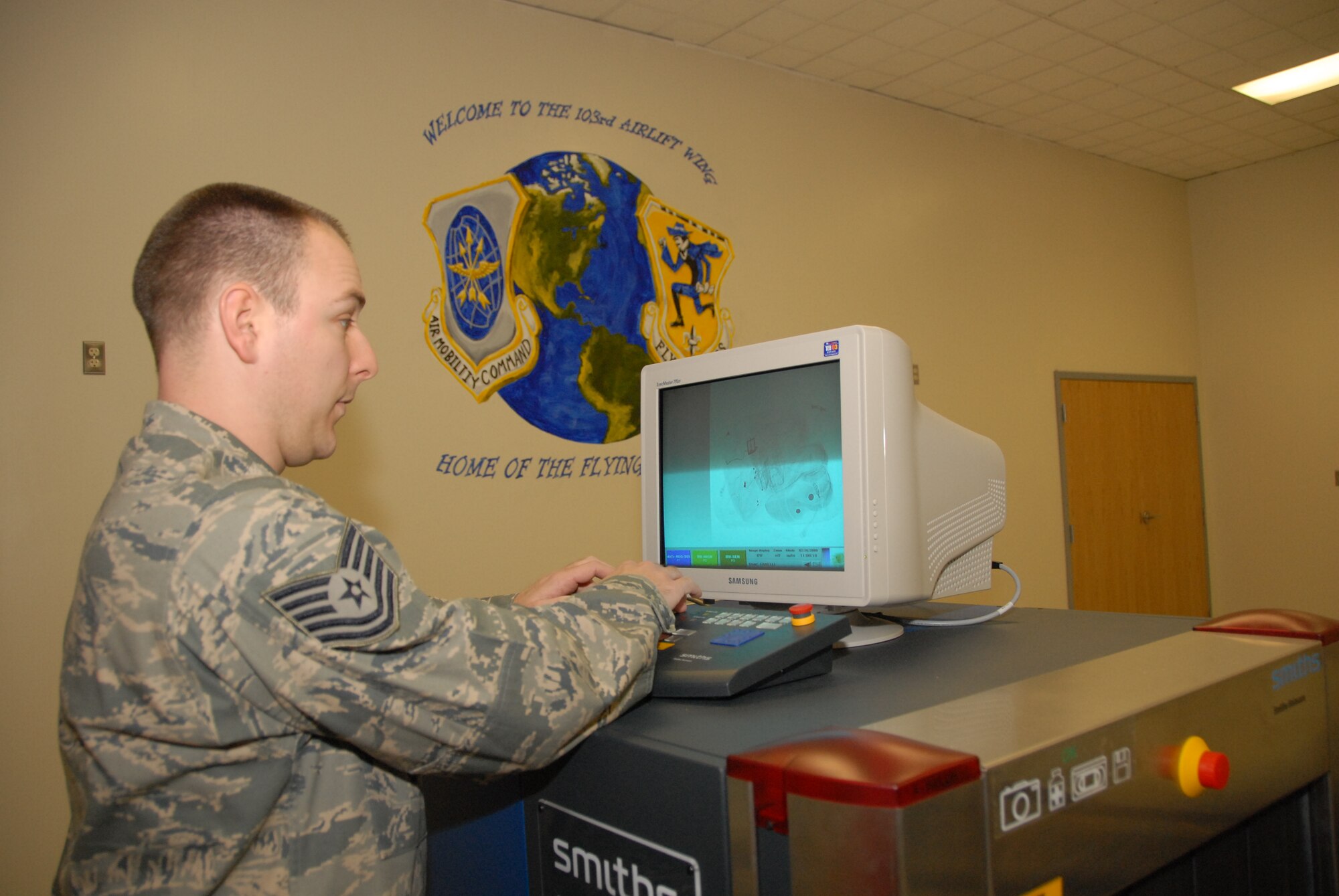 Tech Sgt. Christopher D. Fanelli, air transportation craftsman, 103rd Logistics Readiness Squadron, demonstrates some of the security measures used at the small air terminal at the Bradley Air National Guard Base, East Granby, Conn. Feb. 25, 2009.  (U.S. Air Force Photo by Capt. Bryon M. Turner)
