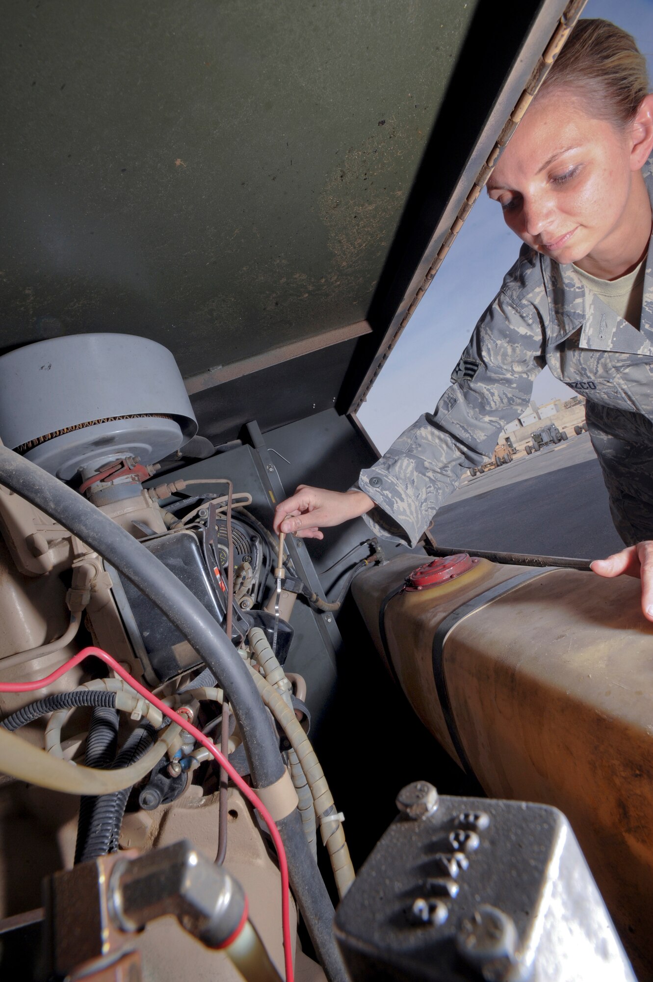 Senior Airman Jessica Orozco, an Aircraft Ground Equipment mechanic with the 379th Expeditionary Maintenance Squadron, checks the oil in an air compressor during a Phase II annual inspection, March 10, 2009, in an undisclosed location in Southwest Asia.  The air compressor is used to bleed out fuel lines and fuel cells in the various aircraft on base.  Airman Orozco is native to Millbrook, Ala. and is deployed from Charleston, S.C., in support of Operations Iraqi and Enduring Freedom and Combined Joint Task Force - Horn of Africa.(U.S. Air Force Photo by Staff Sgt. Joshua Garcia/released)
