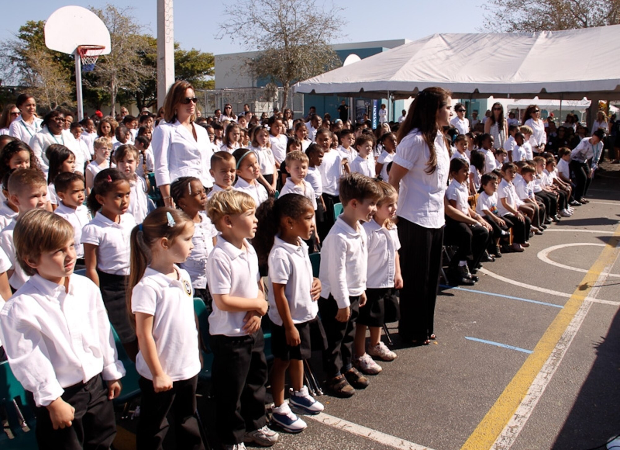 Teachers and students from Air Base Elementary stand during a ceremony recognizing the school’s 50th Anniversary Ceremony on Feb. 27. The elementary school was founded in 1958 on the former Homestead Air Force Base for children of military families. After Hurricane Andrew in 1992, the school's population dwindled and a federal magnet grant was awarded in the summer of 1995 to keep the school from closing. As a result, an International Education Magnet Program was created at the school. (Courtesy photo by Eric Auffhammer)