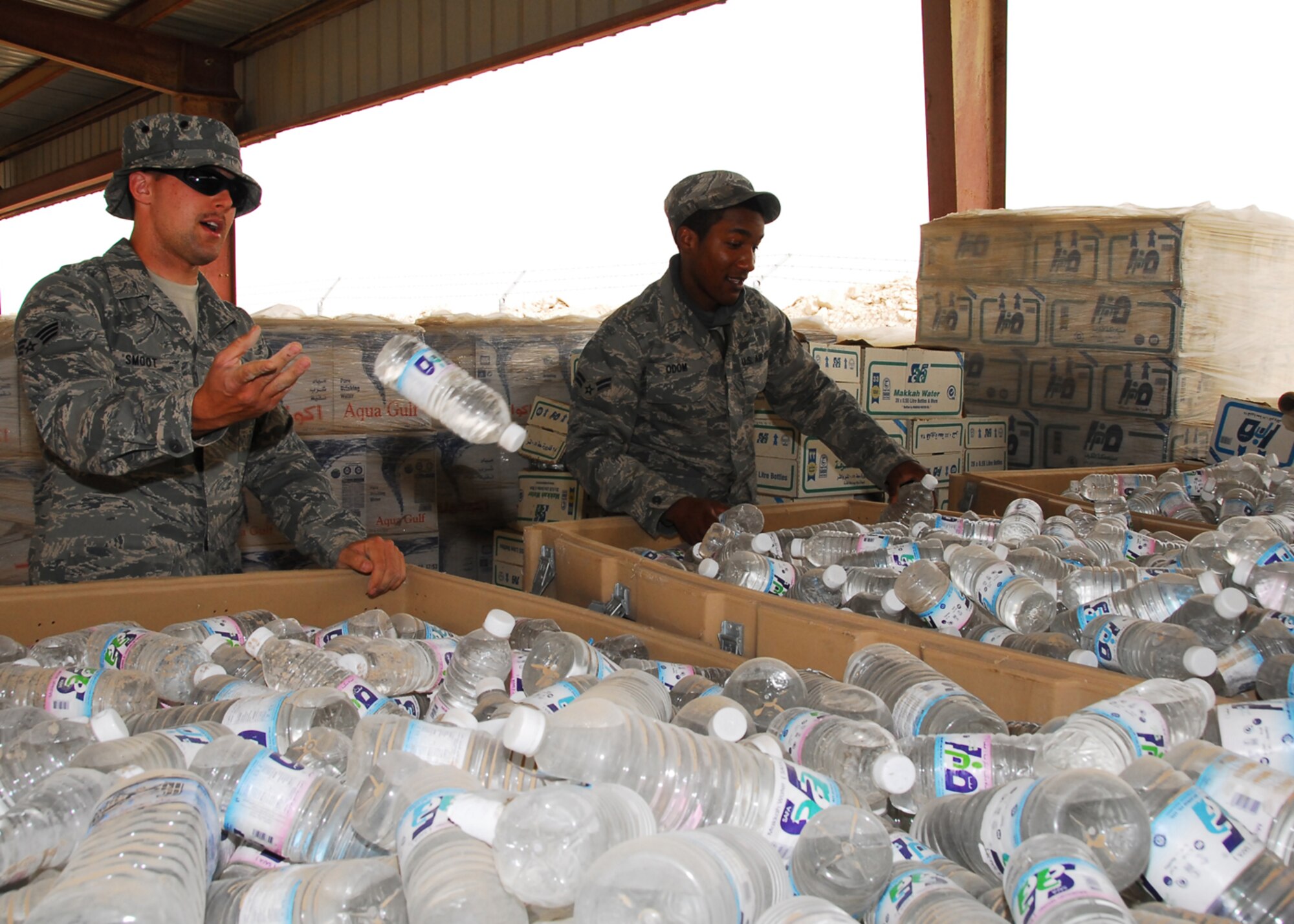 SOUTHWEST ASIA -- Senior Airman Derek Smoot and Airman 1st Class Adrius Odom, 386th Expeditionary Force Support Squadron, sort through water bottles, making sure the appropriate water bottles are in the correct bins, at an air base in Southwest Asia, March 13. Airman Smoot, also known as "the Water Boy," and Airman Odom are responsible for ordering, receiving and maintaining the entire bases's potable water and ice supply. Airman Smoot is currently deployed from Altus Air Force Base, Okla., and is originally from Tulsa, Okla. Airman Odom is currently deployed from Dobbins Air Reserve Base, Ga. and is orginally from Smryna, Ga. (U.S. Air Force photo/Senior Airman Courtney Richardson)