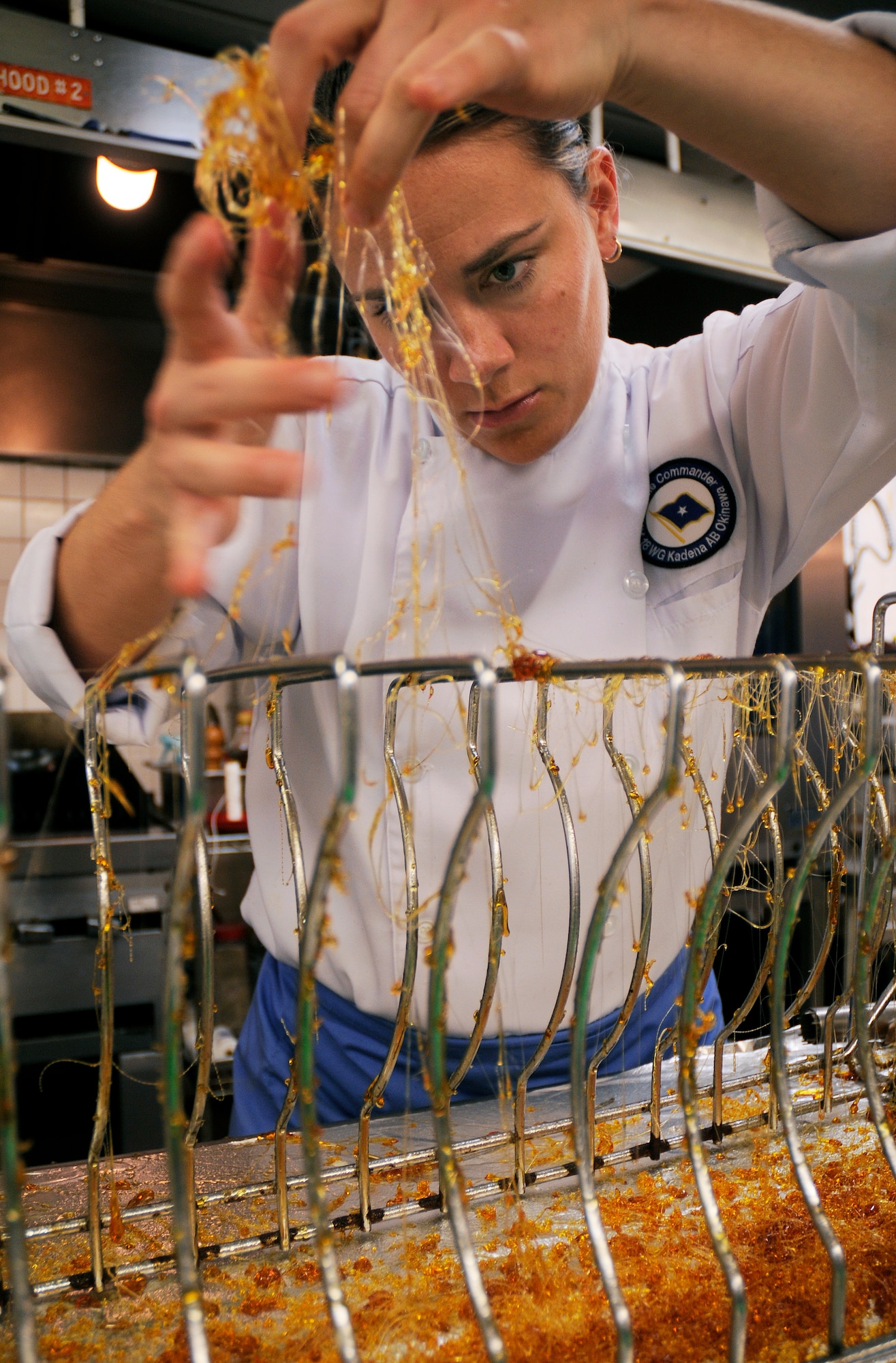 Tech. Sgt. Heather Gray, enlisted aide to the 18th Wing commander, prepares a dessert garnish in the Officer's Club kitchen at Kadena Air Base, Japan March 9, 2009. Team Kadena food service professionals are learning from Chef Dean Nole, who is sharing his talents here for two weeks. (U.S. Air Force photo/Airman 1st Class Chad Warren)