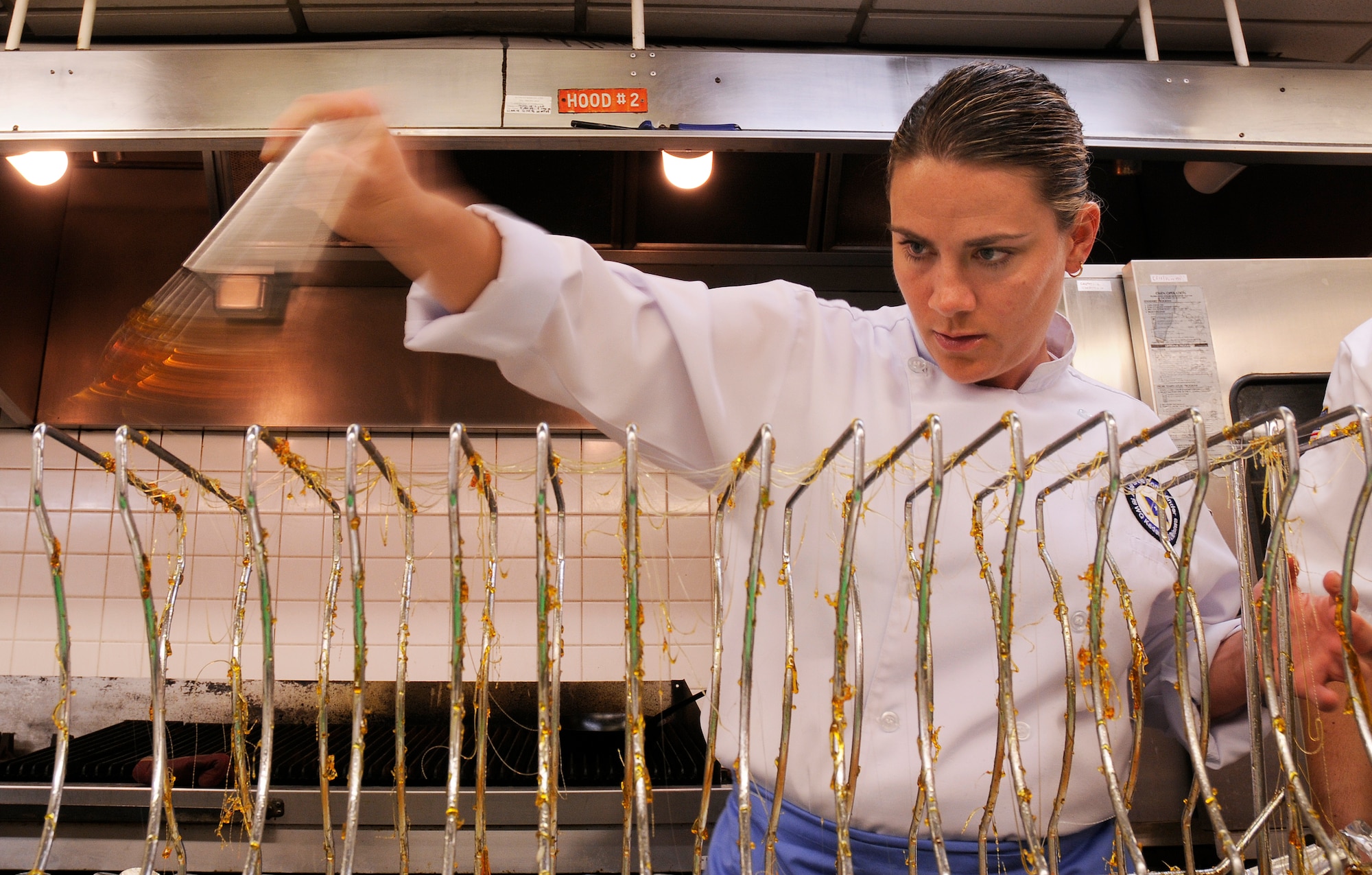 Tech. Sgt. Heather Gray, enlisted aide to the 18th Wing commander, prepares a dessert garnish in the Officer's Club kitchen at Kadena Air Base, Japan March 9, 2009. Team Kadena food service professionals are learning from Chef Dean Nole, who is sharing his talents here for two weeks. (U.S. Air Force photo/Airman 1st Class Chad Warren)