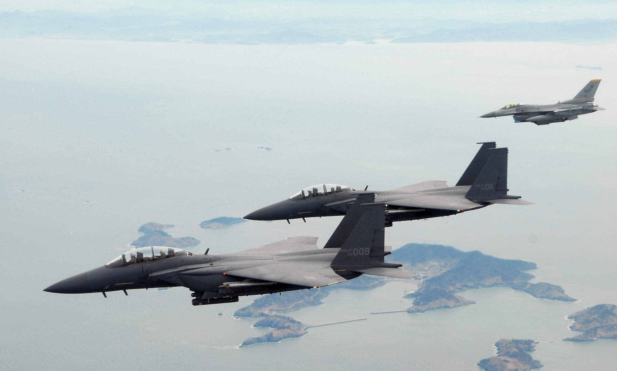 F-15K Slam Eagles from the Republic of Korea Air Force's 11th Tactical Fighter Wing out of Daegu Air Base, fly home with an F-16 Fighting Falcon from Kunsan over Kunsan Air Base, Republic of Korea, Mar. 11 2009. The three aircraft were participating in the Buddy Wing program, an operation designed to increase United States Air Force and ROKAF interoperability. (U.S. Air Force Photo by SSgt Jason Colbert)