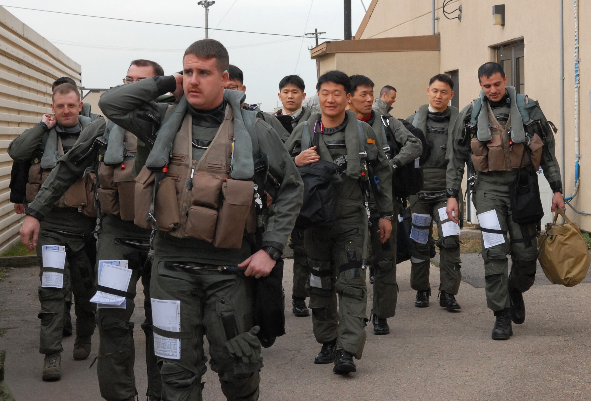Korean and American Airmen step to their jets in preparation for takeoff during the Buddy Bing program at Kunsan Air Base, Republic of Korea, March 11, 2009. The Buddy Wing program is designed to increase United States Air Force and ROKAF interoperability.( U.S. Air Force photo by: Senior Airman Dana Hill)