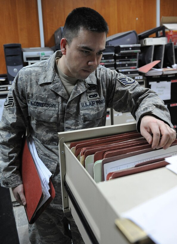 BAGHDAD, Iraq -- Staff Sgt. Adam McConnaughy, paralegal for the 732nd Central Criminal Court of Iraq, sifts through case files on March 3 at Baghadad, Iraq. Paralegals help their lawyer counterparts process legal cases. The Airmen are helping build up Iraq's legal system. McConnaughy,a native of Sacramento, Calif., deployed from McDill Air Force Base, Fla. (U.S. Air Force photo/Senior Airman Tiffany Trojca)