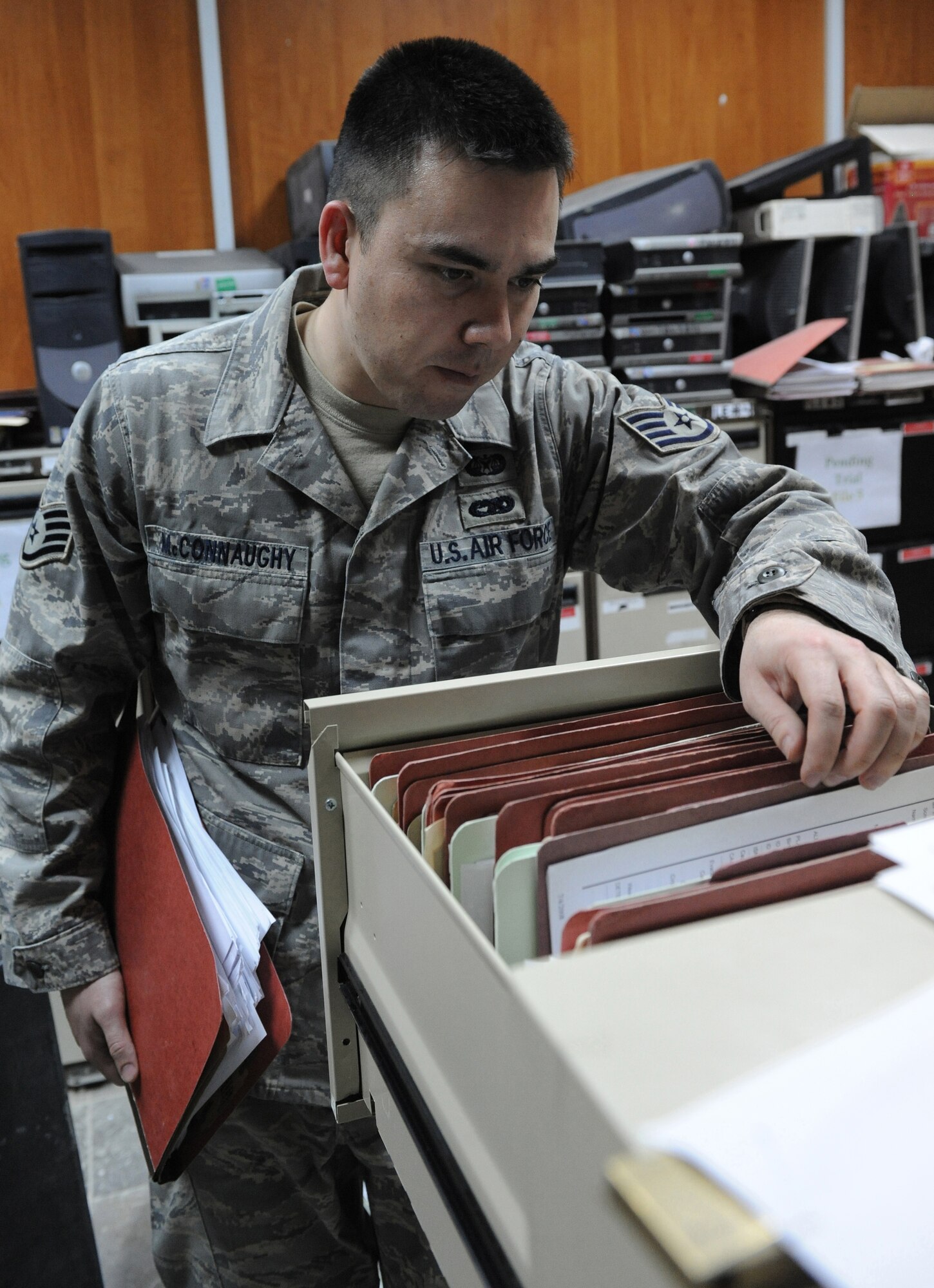 BAGHDAD, Iraq -- Staff Sgt. Adam McConnaughy, paralegal for the 732nd Central Criminal Court of Iraq, sifts through case files on March 3 at Baghadad, Iraq. Paralegals help their lawyer counterparts process legal cases. The Airmen are helping build up Iraq's legal system. McConnaughy,a native of Sacramento, Calif., deployed from McDill Air Force Base, Fla. (U.S. Air Force photo/Senior Airman Tiffany Trojca)