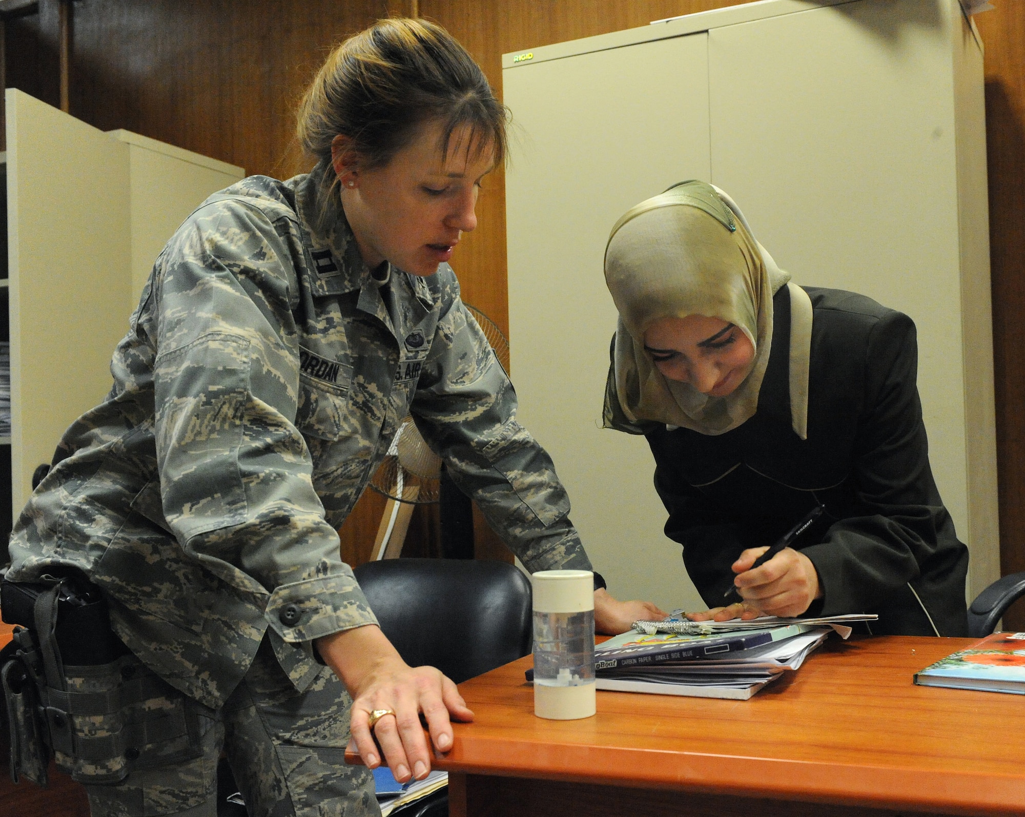 BAGHDAD, Iraq -- Capt. Karen Jordan, lawyer for the 732nd Central Criminal Court of Iraq, and Athra'a, an Iraqi investigator, look over legal files, March 3 at Baghdad, Iraq. The investigators collect evidence and witnesses for trials. Jordan, a native of Raliegh N.C., is deployed from Langley Air Force Base Va. (U.S. Air Force photo/Senior Airman Tiffany Trojca)