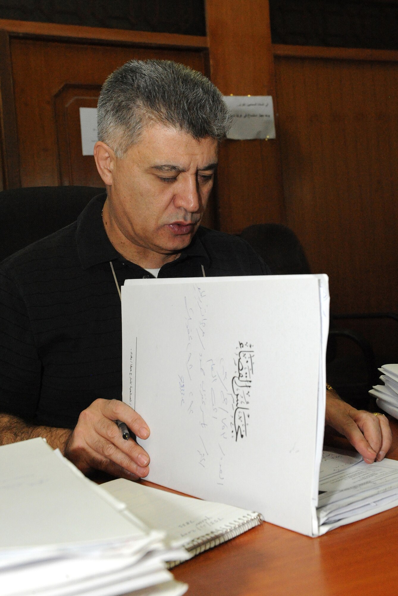 BAGHDAD, Iraq -- Nick, an Arabic interpreter, looks through a legal file March 3 at Baghdad, Iraq. The interpreters help U.S. legal teams prosecute criminals by translating case files. (U.S. Air Force photo/Senior Airman Tiffany Trojca)