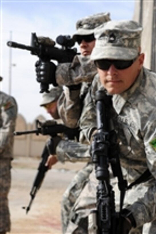 U.S. Army Master Sgt. Robert Eplee, a member of the 6th Iraqi army Military Transition Team, and fellow soldiers prepare to demonstrate how to enter and clear a training room at Joint Security Station Kadhimiya, Iraq, on March 2, 2009.  