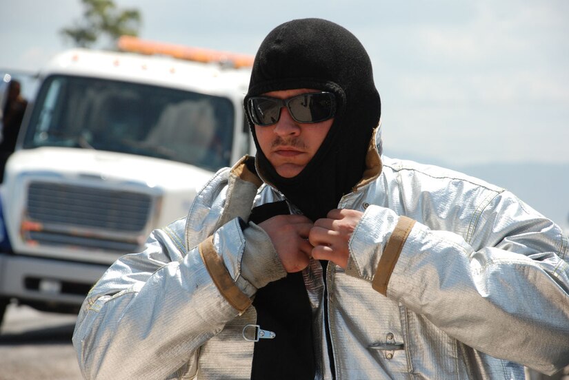 SOTO CANO AIR BASE, Honduras - Joint Task Force-Bravo firefighter Senior Airman Nicholas Fox, dons heavy protective gear when responding to a call for assistance from the Comayagua Fire Department Friday.  The incident involved an overturned fuel tanker carrying 11,000 gallons of butane gas that stopped traffic on C.A. 5 for more than 24 hours.  (U.S. Air Force photo/Tech. Sgt. Rebecca Danét)
  