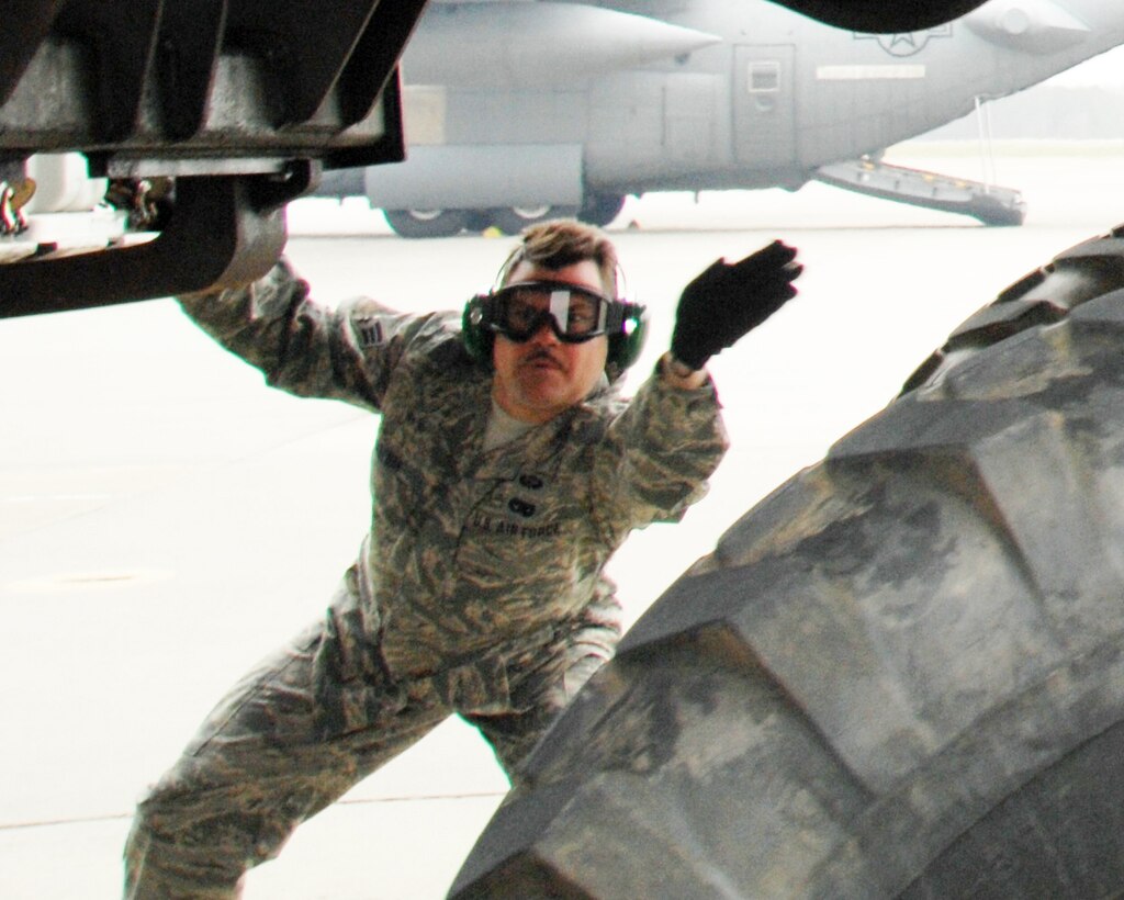 Senior Airman Michael Boehm, a member of the 32nd Aerial Port Squadron, guides a HUMVEE out of a C-130 aircraft in the "Engines Running Off/On Load" exercise during the 22nd Air Force Aerial Port ROUNDUP, a first-of-its-kind event for Reserve aerial port members in 22nd Air Force. (U.S. Air Force photo/1st Lt. J. Justin Pearce) 