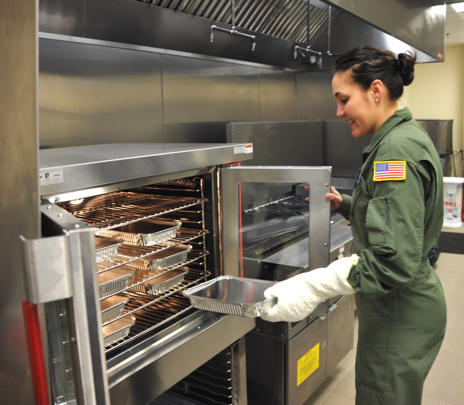 Tech. Sgt. Oriel Rodriguez, a 73rd Airlift Squadron flight attendant, tries out the new convection oven the unit received to support the DV mission. (Photo by Tech. Sgt. Gerald Sonnenberg)
