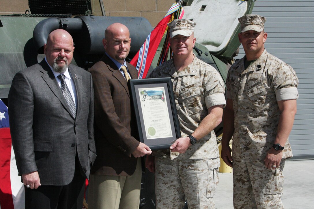 Hemet, Calif., mayor Eric McBride and council member Jim Foreman pose with Lt. Col. Ken Kassner, the commanding officer of 3rd Light Armored Reconnaissance Battalion, and Sgt. Maj. Michael Parks, the battalion sergeant major, with the official adoption proclamation during a ceremony at 3rd LAR’s vehicle ramp March 16.