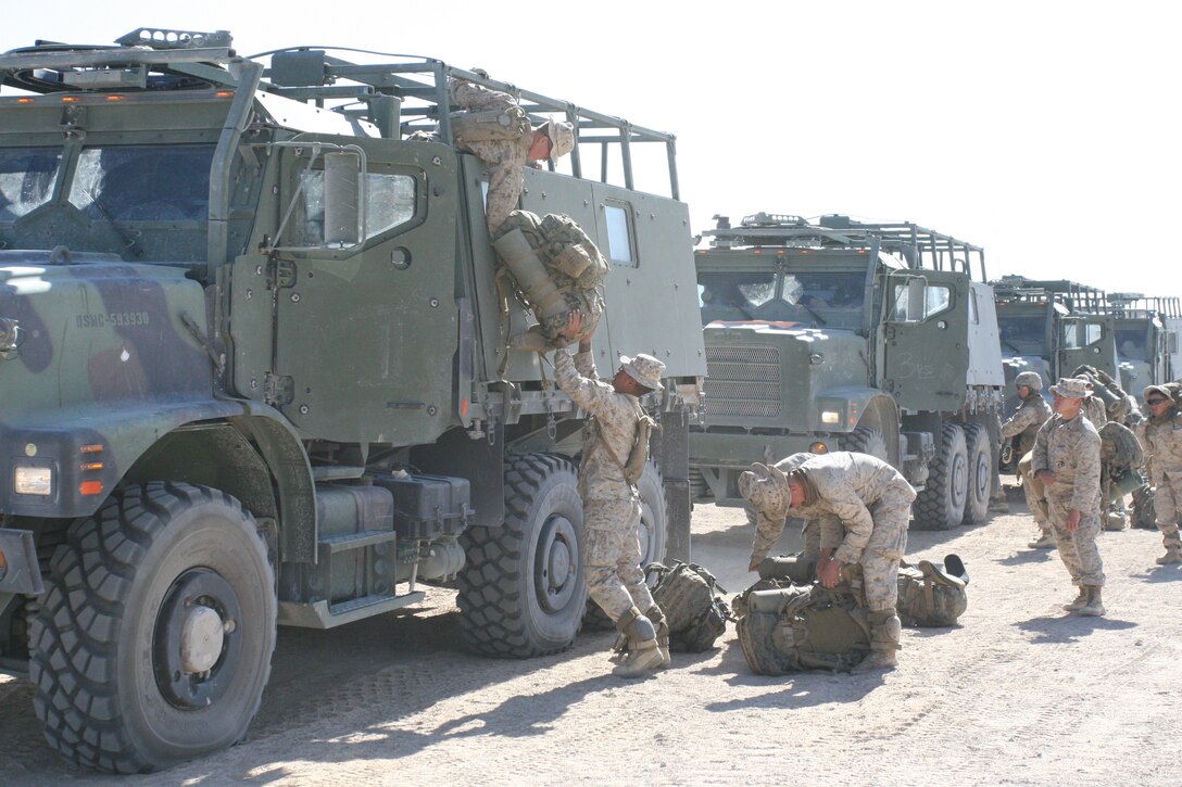 Marines and sailors from 1st Battalion, 5th Marine Regiment load their gear onto a 7-ton truck at Range 215 at the Combat Center before hitching a ride with 1st Platoon, Transport and Support Company with Combat Logistics Battalion 8, during a combined armed exercise March 17.