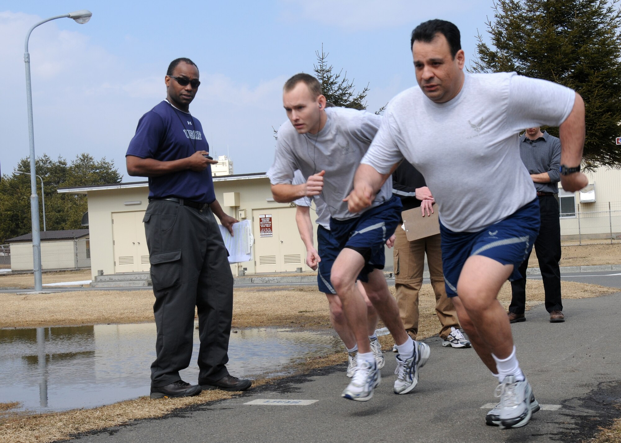 MISAWA AIR BASE, Japan - Orlando Nurse, Health and Wellness Center health technician, times Airmen as they begin the 1.5-mile run during a fitness assessment March 10, 2009. Since March 1, the HAWC has taken over fitness assessments for the base, creating a standardized and central program. (U.S. Air Force photo by Staff Sgt. Rachel Martinez)