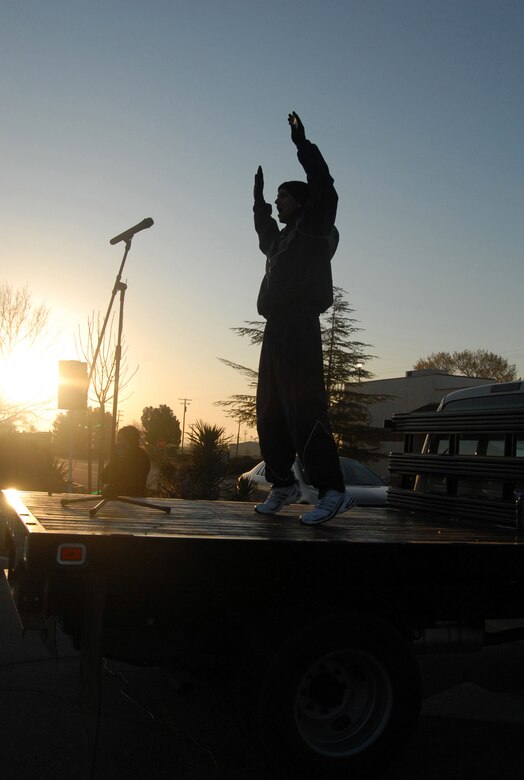 Capt. Jeffrey Scott, 95th Aerospace Medicine Squadron Health and Human Performance Flight commander, leads Edwards Airmen on warm-up exercises at the Base Exchange prior to a formation run March 13. More than 700 Airmen participated in the 2.4-mile run to promote fitness and esprit de corps. (U.S. Air Force photo/Senior Airman Julius Delos Reyes)