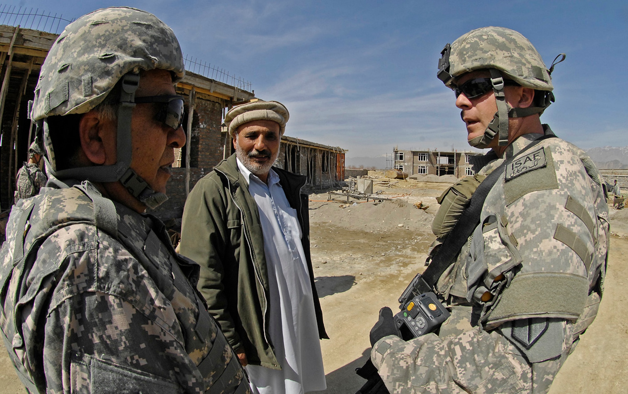 Air Force Master Sgt. Todd Davis, Kapisa/Parwan Provincial Reconstruction Team civil engineer and pay agent, talks with the contractor foreman at the Kapisa Ministry of Education?s education complex construction project near Mahmood Raqi March 14. More than a dozen Soldiers, Airmen and civilian translators assigned to the PRT at Bagram Air Field convoyed March 14 to several construction sites to monitor progress made by local contractors hired to improve local infrastructure. Sergeant Davis, who is deployed from Whiteman Air Force Base, Mo., spoke with the local foreman at the site to see if there were any construction site problems or pay concerns with local workers. The Troy, Ill.-native is one of 24 Airmen assigned to the PRT filling joint expeditionary taskings. (U.S. Air Force photo by Staff Sgt. Jason Lake)