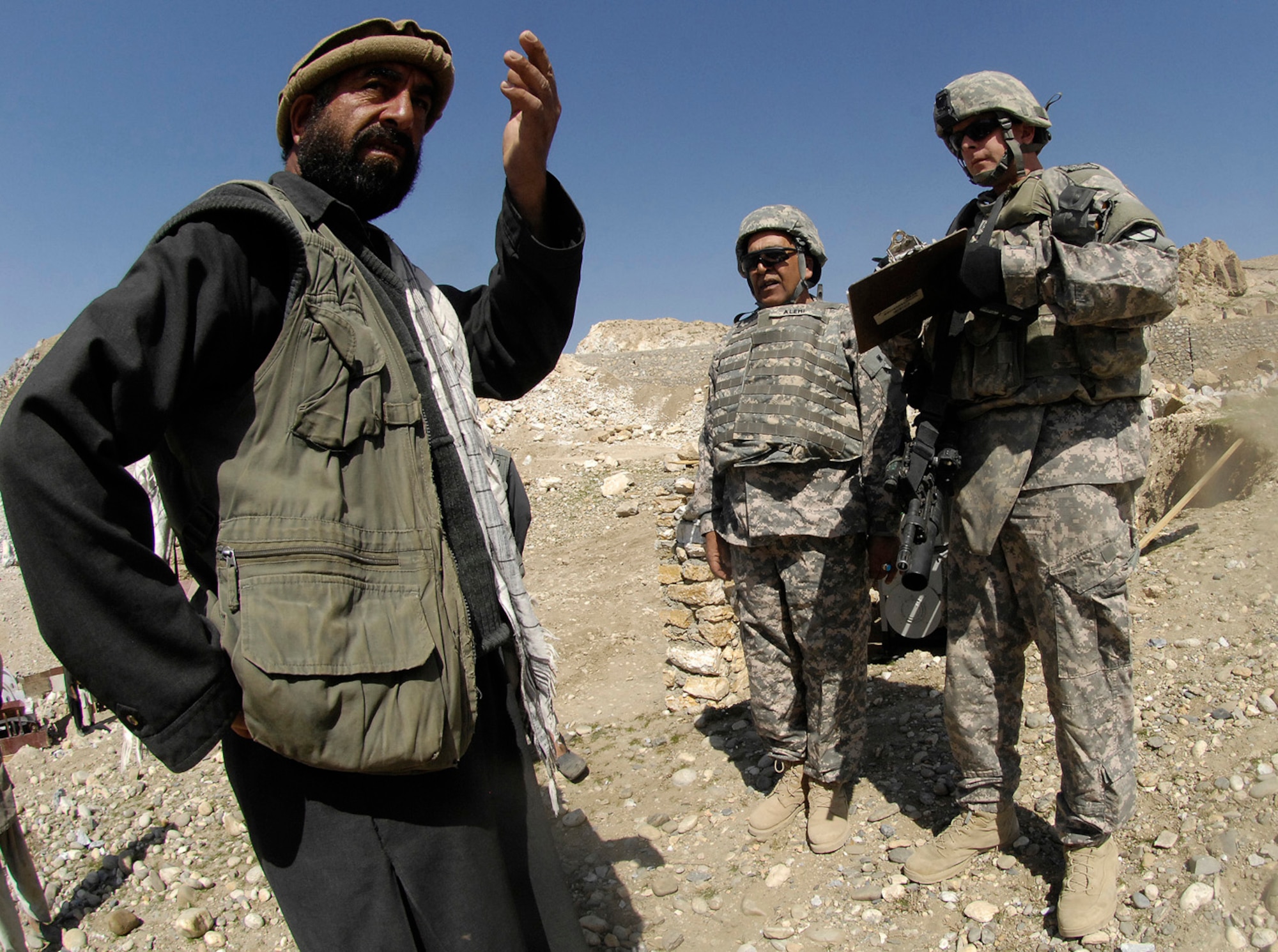 Air Force Master Sgt. Todd Davis, Kapisa/Parwan Provincial Reconstruction Team civil engineer and pay agent, talks with the foreman at a gravel crushing plant near Mahmood Raqi, Afghanistan, March 14. More than a dozen Soldiers, Airmen and civilian translators assigned to the PRT at Bagram Air Field convoyed March 14 to several construction sites to monitor progress made by local contractors hired to improve local infrastructure. Sergeant Davis, who is deployed from Whiteman Air Force Base, Mo., spoke with the local foreman to see if there were any construction site problems or pay concerns with local workers. Sergeant Davis, a Troy, Ill.-native, is one of 24 Airmen assigned to the PRT filling joint expeditionary taskings.(U.S. Air Force photo by Staff Sgt. Jason Lake)