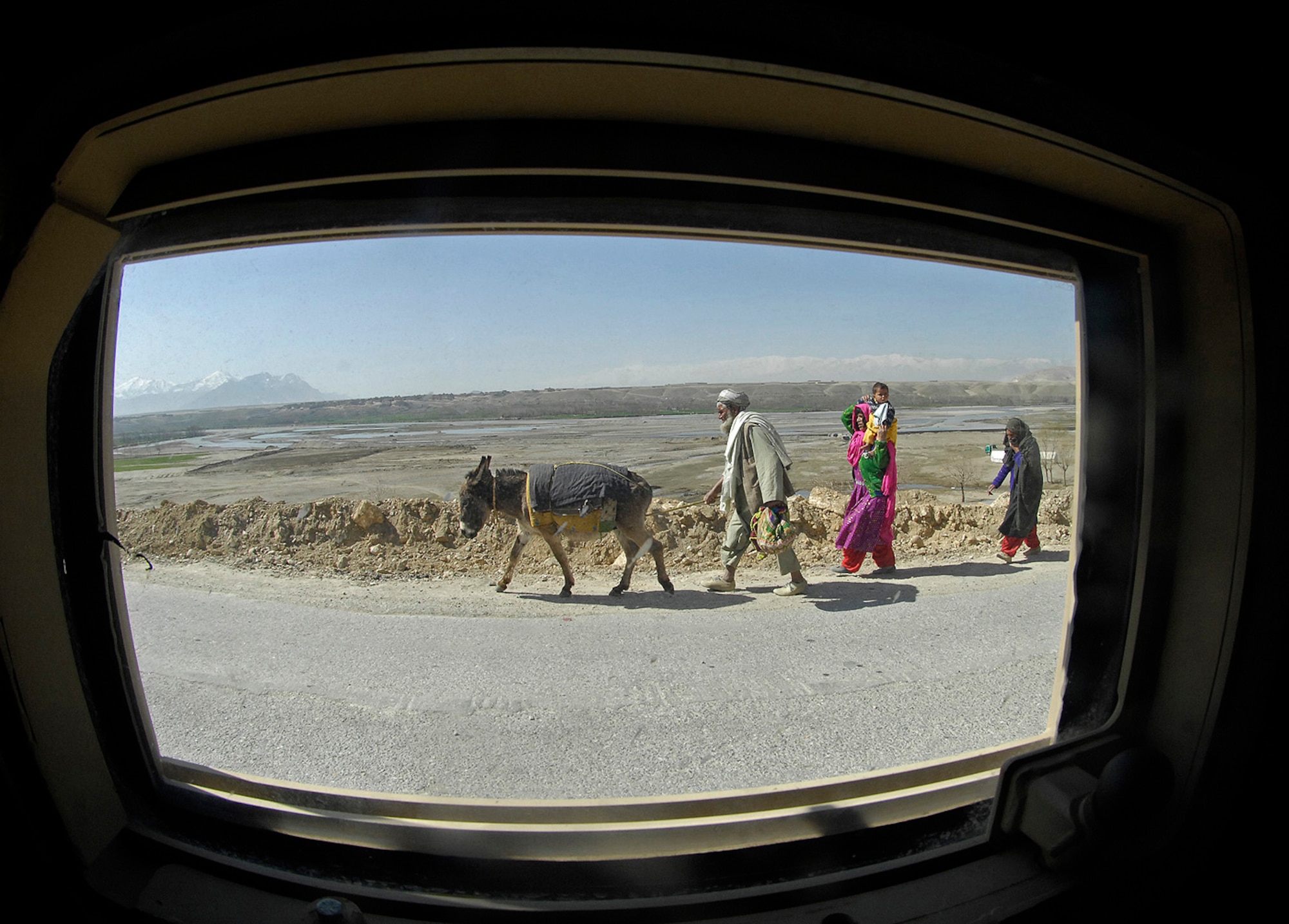 Members of the Kapisa/Parwan Provincial Reconstruction Team pass local villagers on the way to their first objective of the day ? the Masab High School construction site. More than a dozen PRT members convoyed March 14 to the school and two other major projects - a gravel crushing plant and a new ministry of education building near the Kapisa provincial governor's compound. Air Force Master Sgt. Todd Davis, the PRT's civil engineer and pay agent, spoke with foremen at each location and noted the progress made at the work sites. The team also attended a provincial council meeting with local leaders to discuss security measure within the province. Sergeant Davis is deployed from Whiteman Air Force Base, Mo.(U.S. Air Force photo by Staff Sgt. Jason Lake)