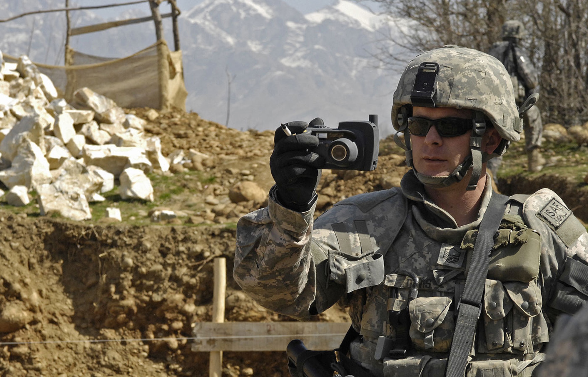 Air Force Master Sgt. Todd Davis, Kapisa/Parwan Provincial Reconstruction Team civil engineer and pay agent, takes photos to document the progress made by contractors hired to build a new high school for students in Mahmood Raqi, Afghanistan. More than a dozen Soldiers, Airmen and civilian translators assigned to the PRT at Bagram Air Field convoyed March 14 to several construction sites to monitor progress made by local contractors hired to improve local infrastructure. Sergeant Davis, who is deployed from Whiteman Air Force Base, Mo., spoke with the local foreman to see if there were any construction site problems or pay concerns with local workers. Sergeant Davis, a Troy, Ill.-native, is one of 24 Airmen assigned to the PRT filling joint expeditionary taskings.(U.S. Air Force photo by Staff Sgt. Jason Lake)
