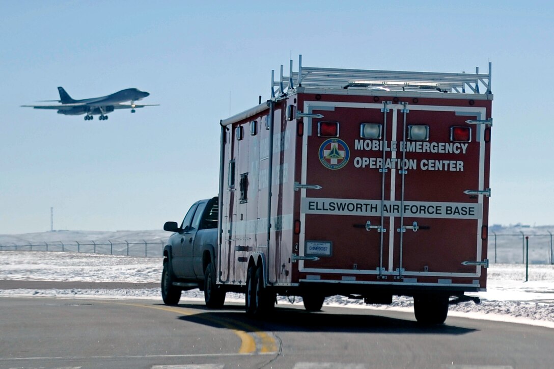 A B-1B Lancer flies overhead as the mobile emergency operations center leaves here to respond to an antiterrorism exercise at Rapid City Regional Airport, S.D., March 12.  Ellsworth Airmen teamed up with their civilian counterparts during the exercise, in an effort to develop a working relationship and become familiar with the policies and procedures of each other. (U.S. Air Force photo/Airman 1st Class Matthew Flynn)


