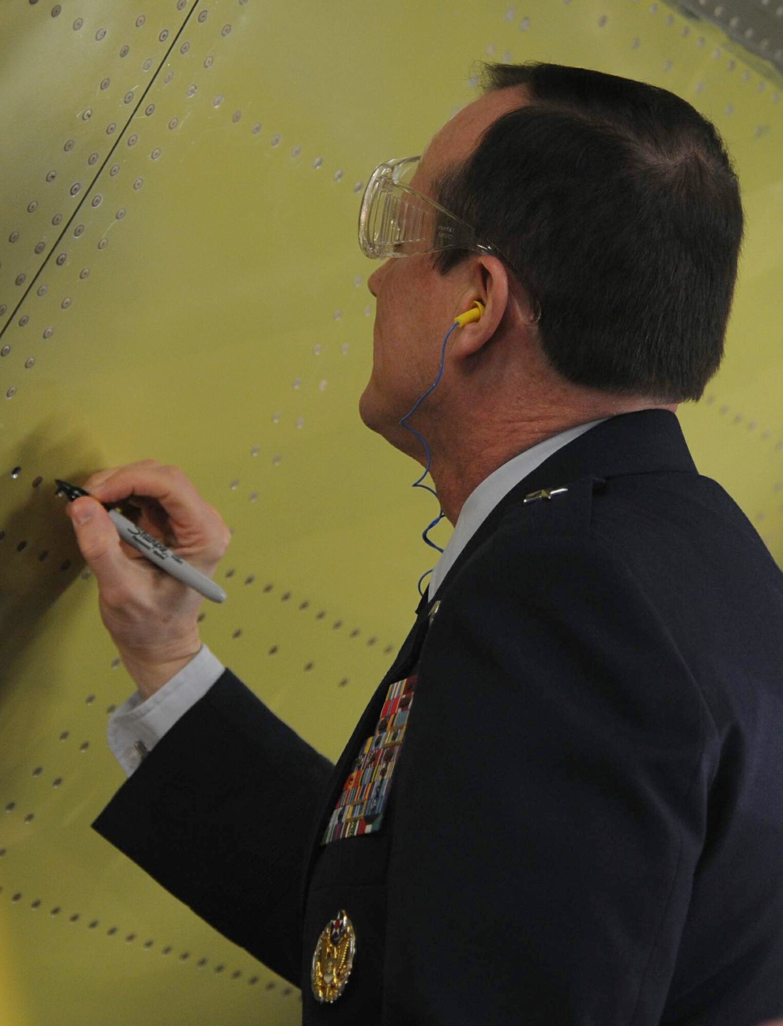 In his multinational role as chairman of the 12-nation Strategic Airlift Capability consortium, Brig. Gen. Richard Johnston signed the forward fuselage of the program's first C-17 Globemaster III after having driven a ceremonial rivet into the airframe during the "major join" ceremony at the Boeing final assembly facility.  The C-17 will be delivered to the Heavy Airlift Wing, the SAC program's multinational operational unit, at Papa Air Base, Hungary, in July. (U.S. Air Force photo/Atiba Copeland)
