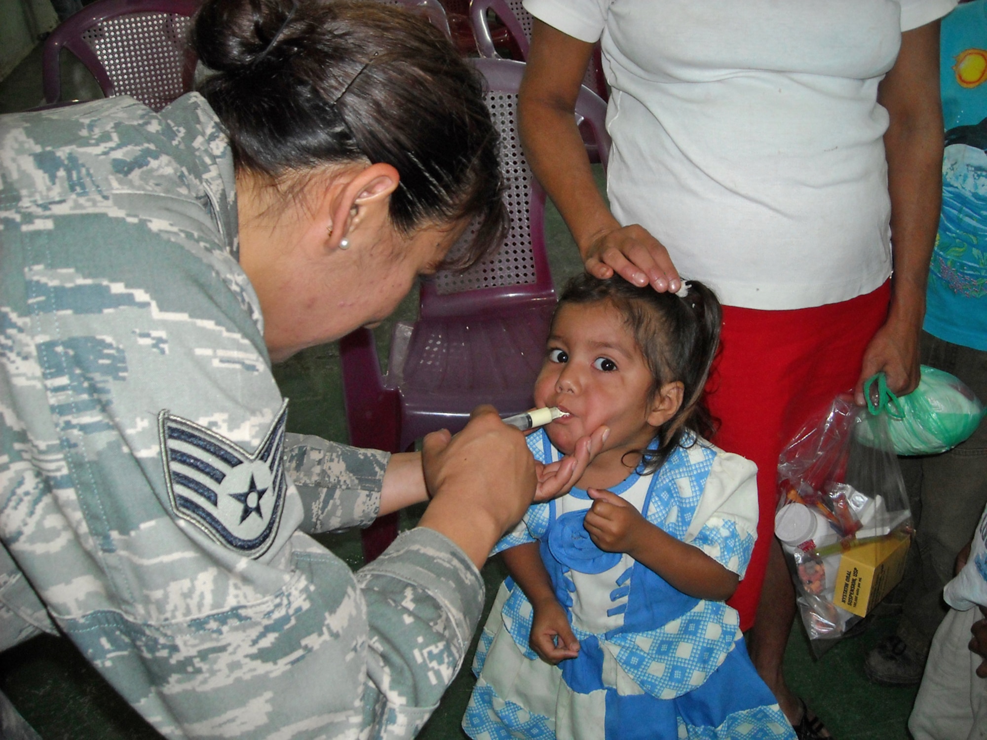 Staff Sgt. Marina Coronado gives medicine to a local girl during a four-month deployment to Honduras. Assisting a preventive medicine team was one her favorite parts of the deployment. Sergeant Coronado is an information manager assigned to the 931st Operations Support Flight. (Courtesy photo)          