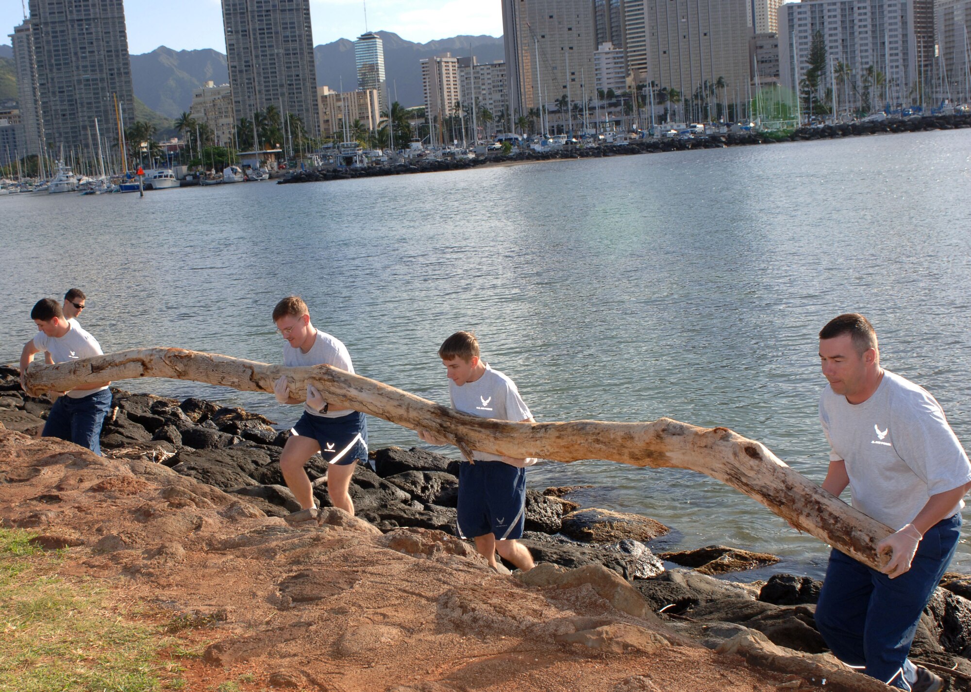 Airman Chris Yanchun, (left to right) Maj. Matthew Stratton, Airman 1st Class Darrin Potter and Master Sgt. Donavon Schaefer lift a large driftwood log from the rocky shoreline March 13 along Ala Moana Beach Park in Honolulu. The Airmen volunteered for the beach cleanup as part of 13th Air Force's Jungle Day, a tradition for the Hickam Air Force Base unit that occurs every Friday the 13th. (U.S. Air Force photo/Oscar A. Hernandez) 
