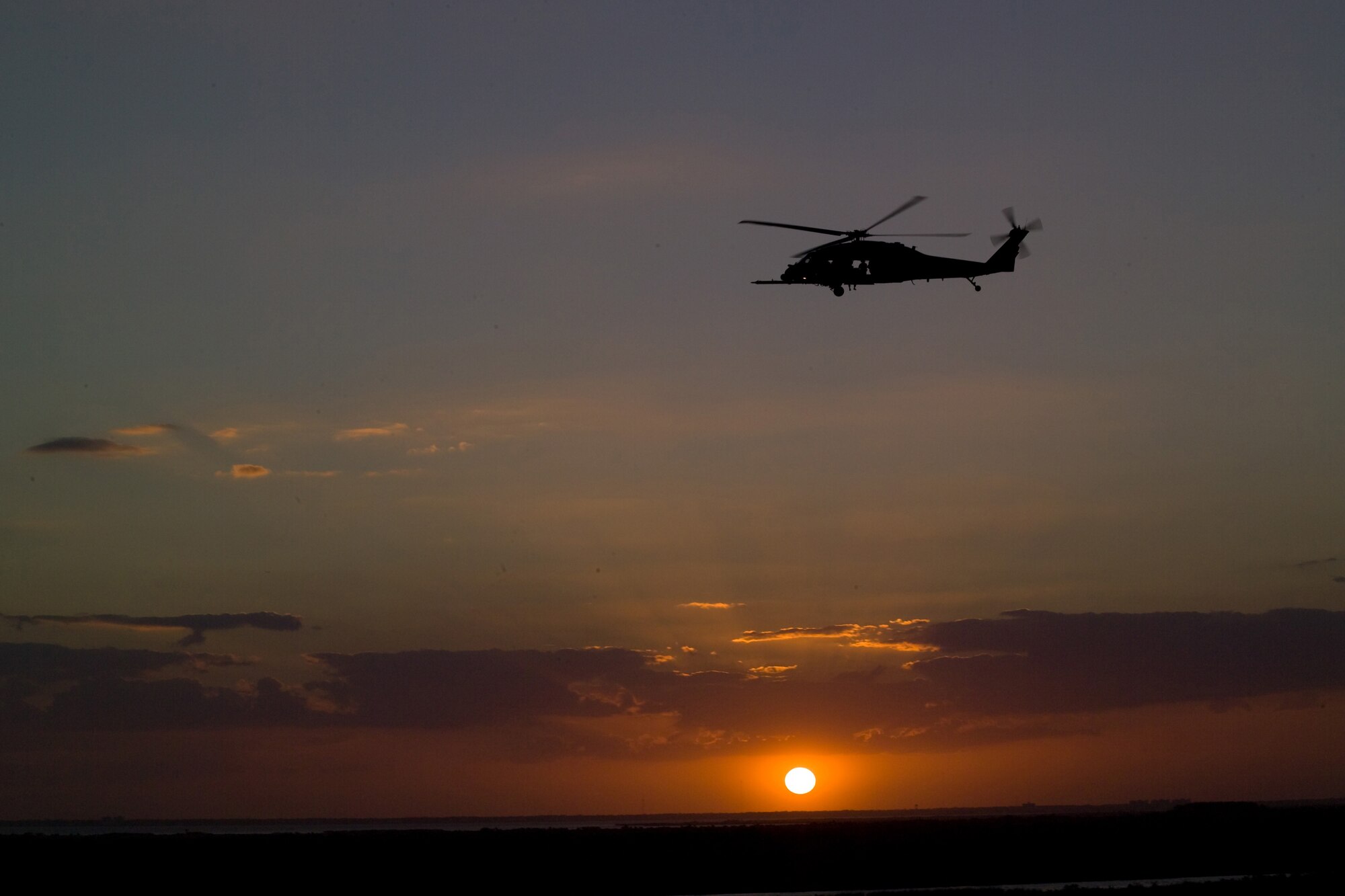 KENNEDY SPACE CENTER, Fla. -- An HH-60G Pave Hawk helicopter patrols the sky over NASA's Kennedy Space Center in preparation for launch of Space Shuttle Discover March 15. At exactly 7:43 p.m., the shuttle's massive engines erupted in a tower of flame, sending the shuttle on its way to the International Space Station, where it will deliver a final pair of power-generating, solar-array wings and a truss segment. The 920th Rescue Wing provides first-response emergency medical and search-and-rescue support for every NASA shuttle and rocket launch. (Courtesy photo NASA/Jeff Wolfe)