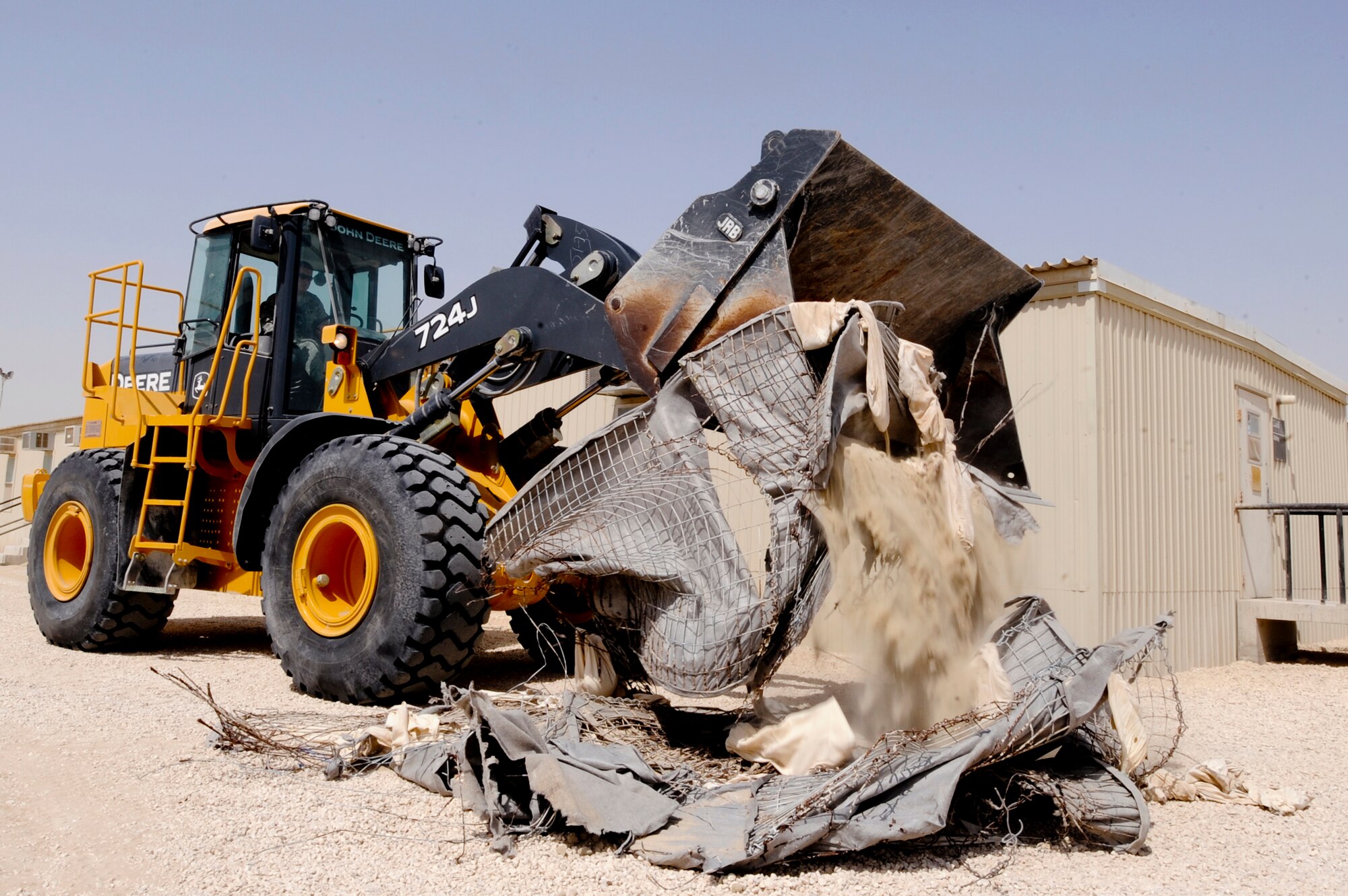 Senior Airman Drew Harrison, a Heavy Equipment Operator with the 379th Expeditionary Civil Engineer Squadron, uses a front end loader to tear down an old bunker, March 16, 2009, in an undisclosed location in Southwest Asia.  The bunkers in the living areas are being rebuilt to hold and protect more personnel in case of attack.  Airman Harrison hails from Austin, Texas and is deployed from Lackland Air Force Base, Texas in support of Operations Iraqi and Enduring Freedom and combined Joint Task Force - Horn of Africa. (U.S. Air Force Photo by Staff Sgt. Joshua Garcia/released)