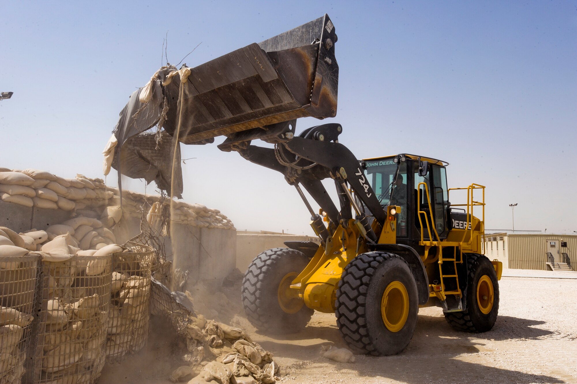 Senior Airman Drew Harrison, a Heavy Equipment Operator with the 379th Expeditionary Civil Engineer Squadron, uses a front end loader to tear down an old bunker, March 16, 2009, in an undisclosed location in Southwest Asia.  The bunkers in the living areas are being rebuilt to hold and protect more personnel in case of attack.  Airman Harrison hails from Austin, Texas and is deployed from Lackland Air Force Base, Texas in support of Operations Iraqi and Enduring Freedom and combined Joint Task Force - Horn of Africa. (U.S. Air Force Photo by Staff Sgt. Joshua Garcia/released)