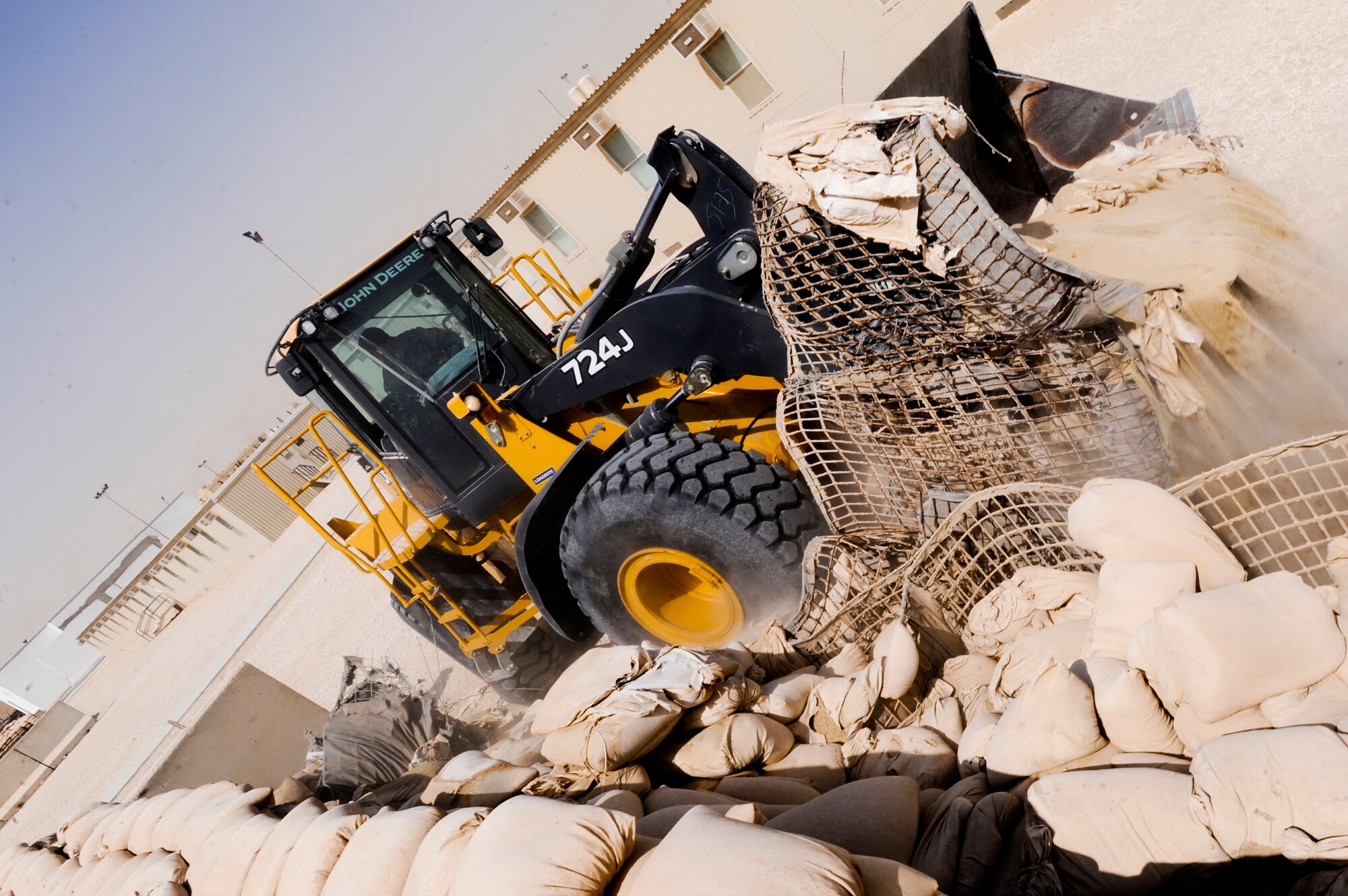 Senior Airman Drew Harrison, a Heavy Equipment Operator with the 379th Expeditionary Civil Engineer Squadron, uses a front end loader to tear down an old bunker, March 16, 2009, in an undisclosed location in Southwest Asia.  The bunkers in the living areas are being rebuilt to hold and protect more personnel in case of attack.  Airman Harrison hails from Austin, Texas and is deployed from Lackland Air Force Base, Texas in support of Operations Iraqi and Enduring Freedom and combined Joint Task Force - Horn of Africa. (U.S. Air Force Photo by Staff Sgt. Joshua Garcia/released)
