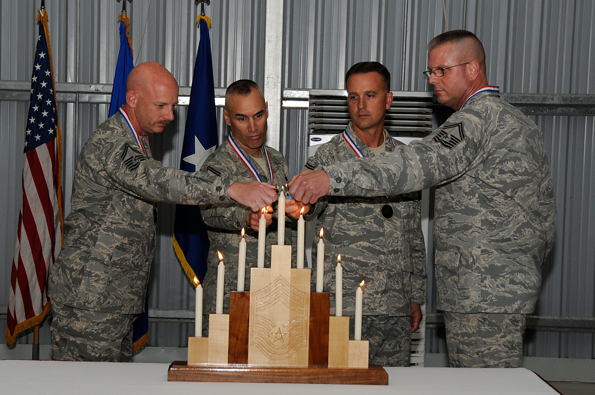 SOUTHWEST ASIA - (Left to Right) Senior Master Sgt. James Leichtenberg, Senior Master Sgt. Scott Robbins, Senior Master Sgt. James Williams, 380th Expeditionary Maintenance Group and Senior Master Sgt. Jeffrey Wilson, 363rd Training Group light the last candle during the Chief Master Sergeant Recognition Ceremony, Mar 14. Tradition states a member of each rank lights a candle signifying the transition through the ranks from Airman Basic to Chief Master Sergeant. The four SMSgt's will all pin on Chief in the coming months adding a new chapter to their Air Force career.  Sergeant Leichtenberg is deployed from Offutt AFB, Neb. Sergeant Robbins is deployed from Davis-Monthan AFB, Ariz. Sergeant Williams is deployed from Travis AFB, Calif. (U.S. Air Force photo by Senior Airman Brian J. Ellis) (Released)