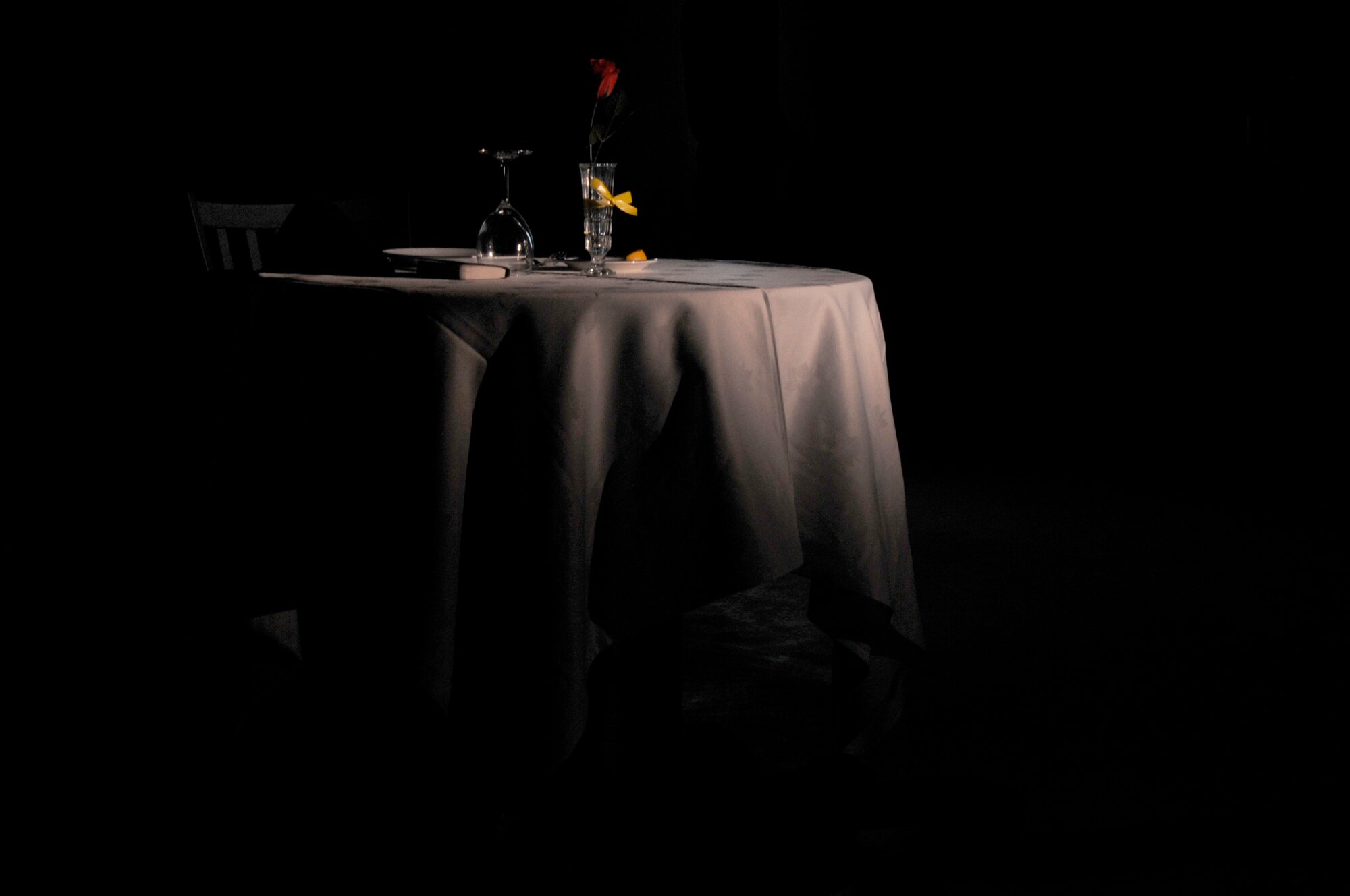 SOUTHWEST ASIA - A lone table sits with a spotlight prior to the start of the Chief Master Sergeant Recognition Ceremony held at the 380th Air Expeditionary Wing, Mar 14. The table was set as part of a POW/MIA remembrance. The room filled with a moment of silence followed by a toast to honor those fallen. (U.S. Air Force photo by Senior Airman Brian J. Ellis) (Released)