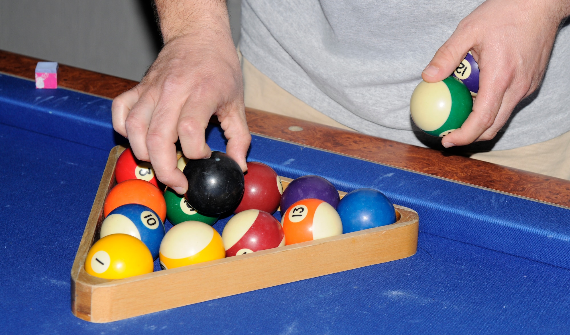 Tech Sgt. Russell Cooper, 39th Air Base Wing, sets up the rack before a game against another participant during a round of eight-ball during a pool tournament at the Consolidated Club March 12. More than 15 participants competed for a first place prize of a $150 cash, and a custom pool stick for second and third place prizes. (U.S. Air Force photo/Airman 1st Class Amber Russell)