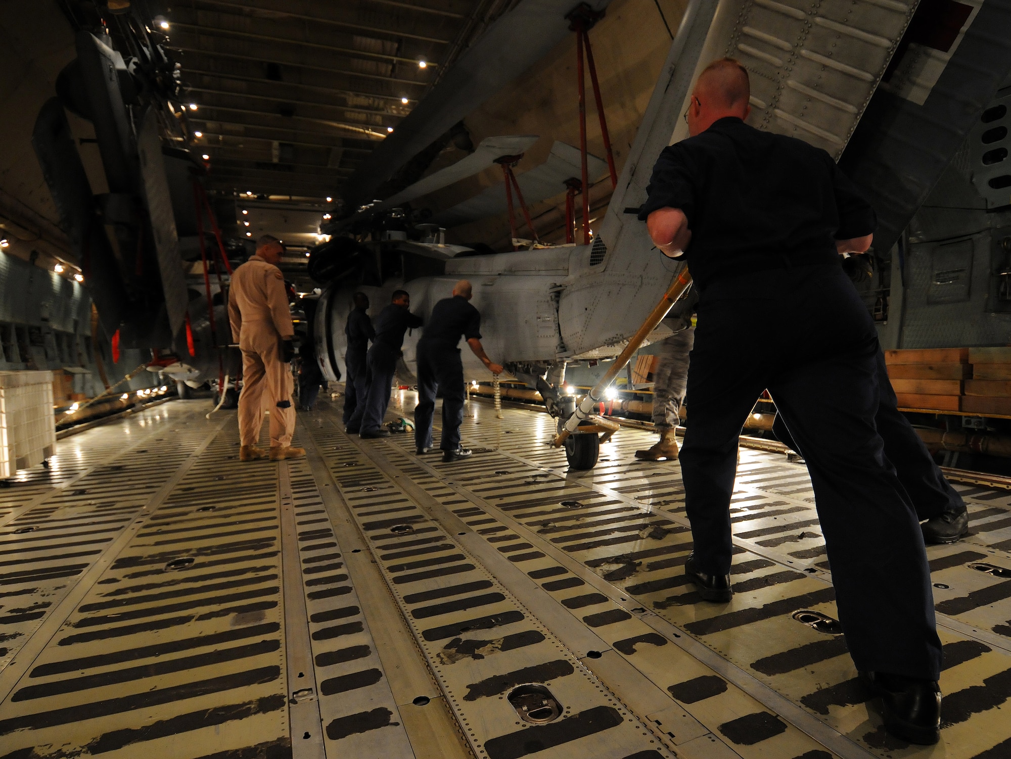 ANDERSEN AIR FORCE BASE, Guam – Senior Master Sgt. Randall Shafer, 167th Airlift Wing load master, monitors as Sailors from the Helicopter Sea Combat Squadron TWO FIVE position an MH-60S Knighthawk inside a C-5 Galaxy on the flightline at Andersen Air Force Base, Guam, March 13, 2009.  The Air Force aircrew and the Navy sailors loaded three MH-60S and two SH-60H helicopters inside the cargo aircraft for transportation to Island Naval Air Station, San Diego.  The event was the first time a C-5 aircrew has moved five of that airframe at one time.  The C-5 was from the 167th AW, Martinsburg, W. Va. (U.S. Air Force photo by Airman 1st Class Courtney Witt)


