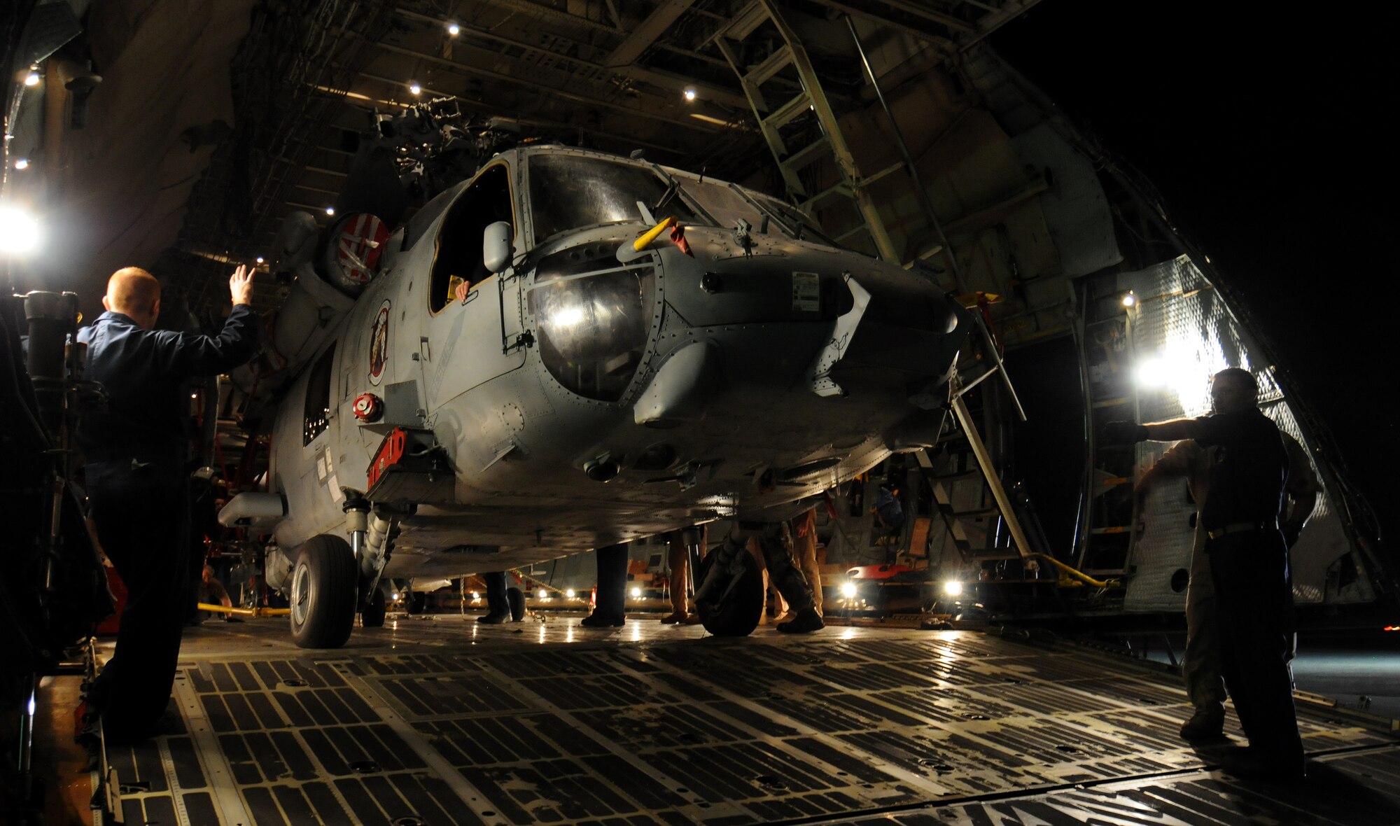 ANDSERSEN AIR FORCE BASE, Guam - Sailors from the Helicopter Sea Combat Squadron TWO FIVE guide the last out of five helicopters into the cargo bay of a C-5 Galaxy on the flightline at Andersen Air Force Base, Guam, March 13, 2009. Air Force load teams from 734th Air Mobility Squadron, Air National Guardsmen from the 167th Airlift Wing, Martinsburg, W. Va., and Navy sailors from Helicopter Sea Combat Squadron TWO FIVE loaded three MH-60S and two SH-60H helicopters inside the cargo aircraft for transportation to Island Naval Air Station, San Diego.  The event was the first time a C-5 aircrew has moved five of that airframe at one time.  (U.S. Air Force photo by Airman 1st Class Courtney Witt) 

