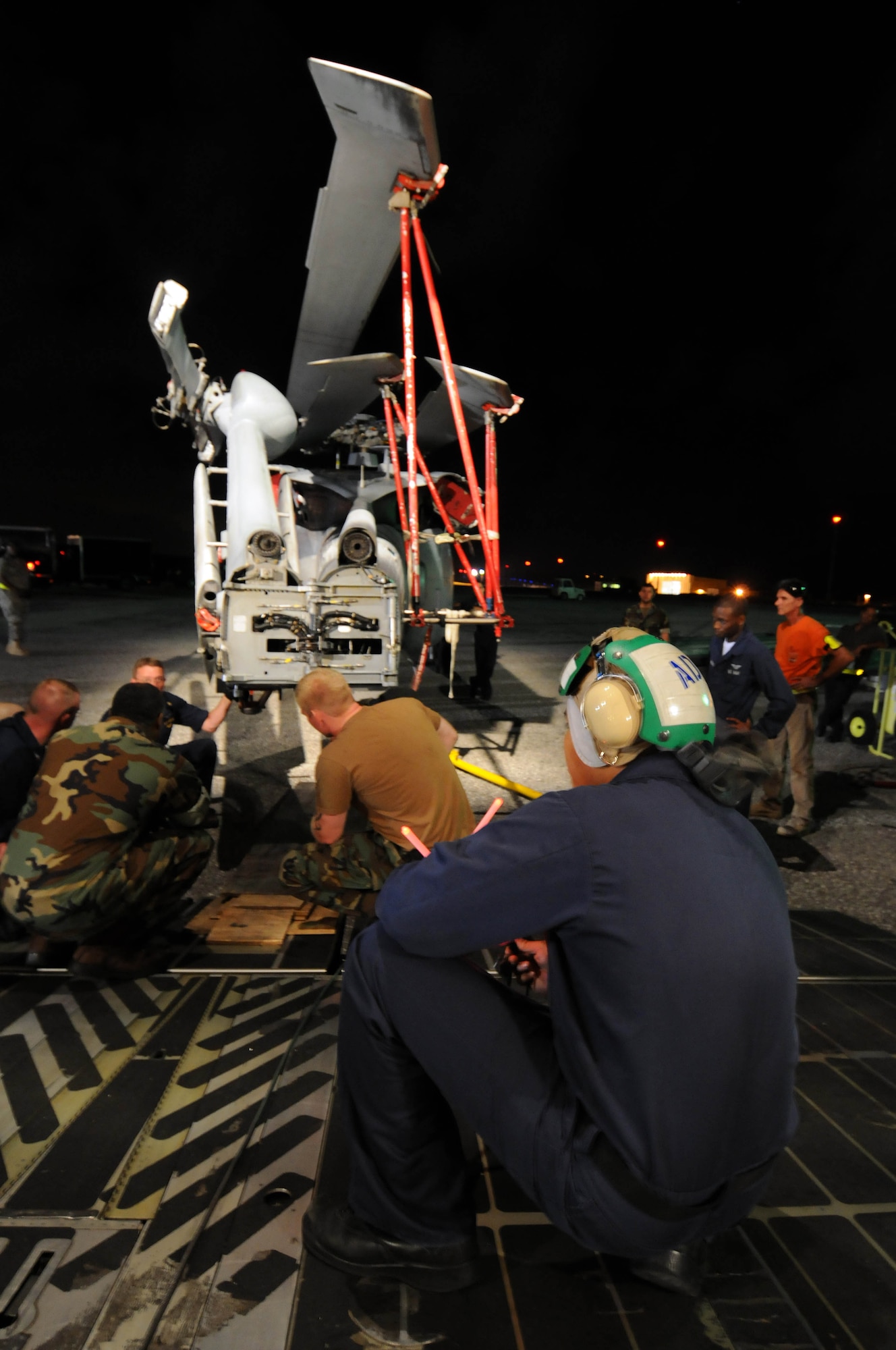 ANDSERSEN AIR FORCE BASE, Guam – Sailors from Helicopter Sea Combat Squadron TWO FIVE, Air National Guardsmen from the 167th Airlift Wing, Martinsburg, W. Va., and Airmen from the 734th Air Mobility Squadron load the fifth and final helicopter onto a C-5 Galaxy on the flightline at Andersen Air Force Base, Guam, March 13, 2009. It took the load team six hours to secure the five helicopters for delivery to San Diego. (U.S. Air Force photo by Airman 1st Class Courtney Witt)
