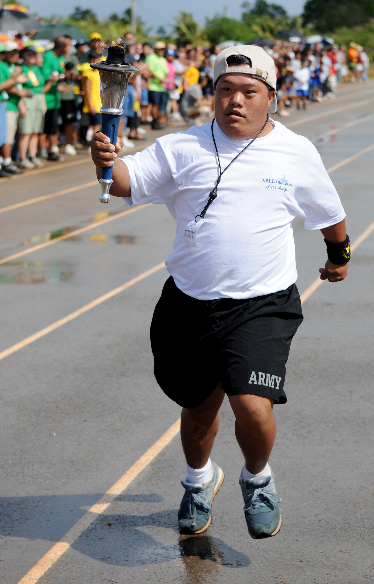 ANDERSEN AIR FORCE BASE, Guam - Quentin San Nicolas from Team Able Industries of the Pacific runs the last leg of the torch that will light the flame to start the Special Olympics at the Okkodo High School track March 14. Representatives from various Air Force and Navy squadrons and commands spent the past 10 weeks coaching athletes at their sister schools for the big event.(U.S. Air Force photo by Airman 1st Class Courtney Witt)

