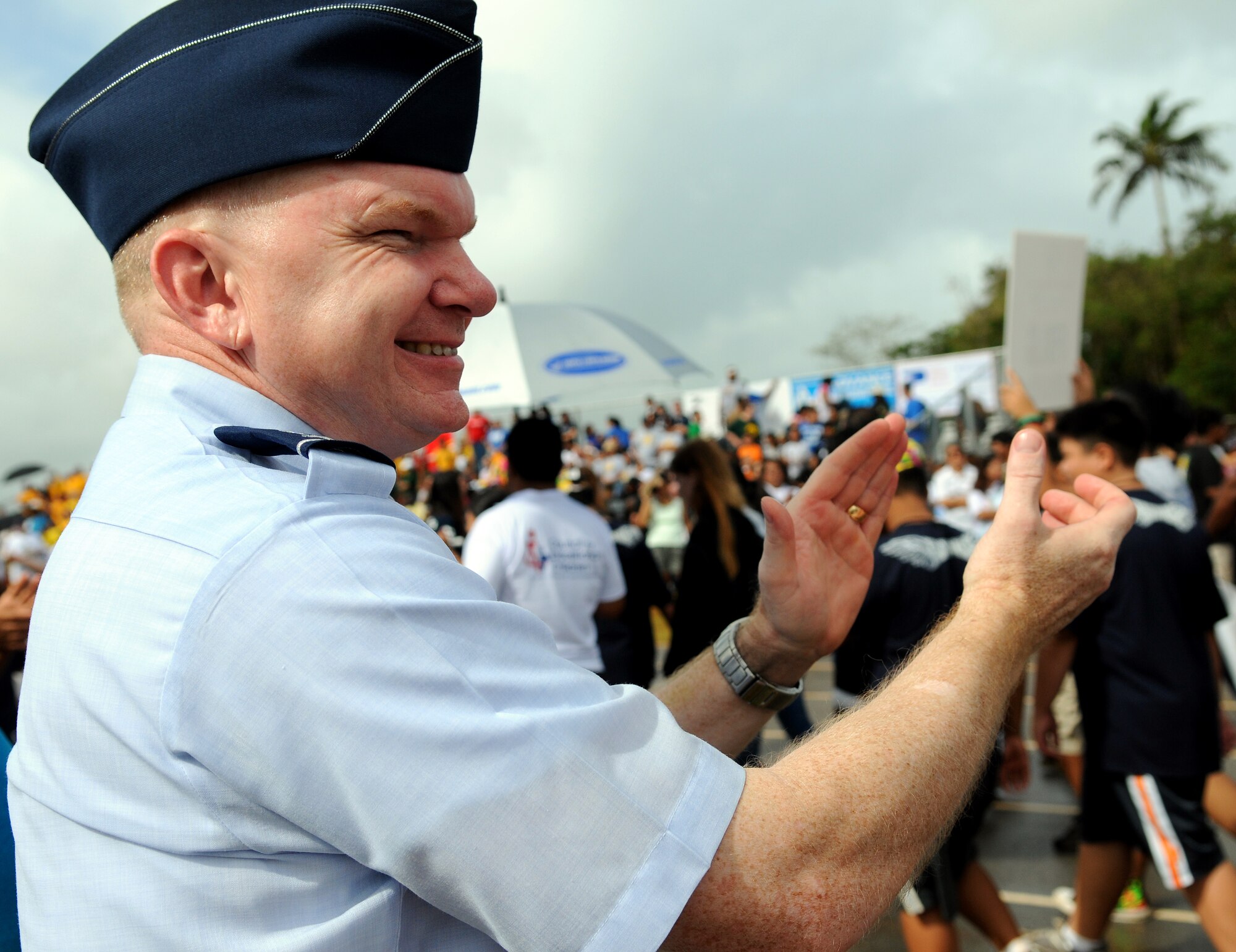 ANDERSEN AIR FORCE BASE, Guam - Andersen's 36th Mission Support Group Commander, Col. Mark Talley, cheers on the Olympians as they parade around the track during the opening ceremony for the 33rd annual track and field Special Olympics at Okkodo High School in Dededo, Guam March 14. Both Air Force and Navy alike pulled together to volunteer for the event. (U.S. Air Force photo by Airman 1st Class Courtney Witt)

