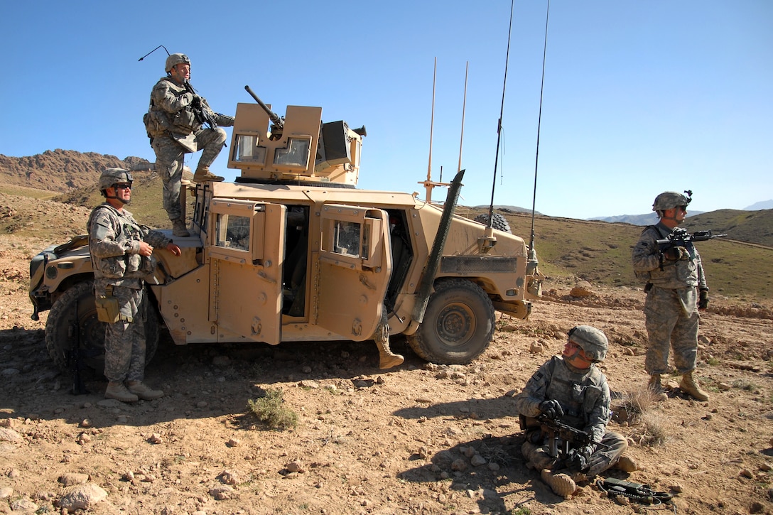 U.S. Army 1st Lt. Jared Tomberlin climbs on a Humvee for a better view ...