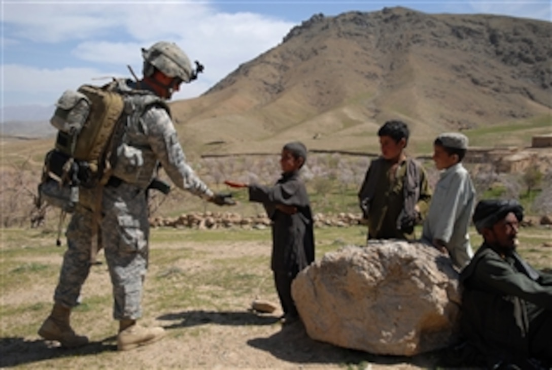 U.S. Army Spc. Jackie Greenlee, a medic with Bravo Company, 1st Battalion, 4th Infantry Regiment, U.S. Army Europe, teaches a local boy how to give a high five near Forward Operating Base Lane, Zabul, Afghanistan, on March 11, 2009.  Greenlee is on a humanitarian aid mission near the base.  