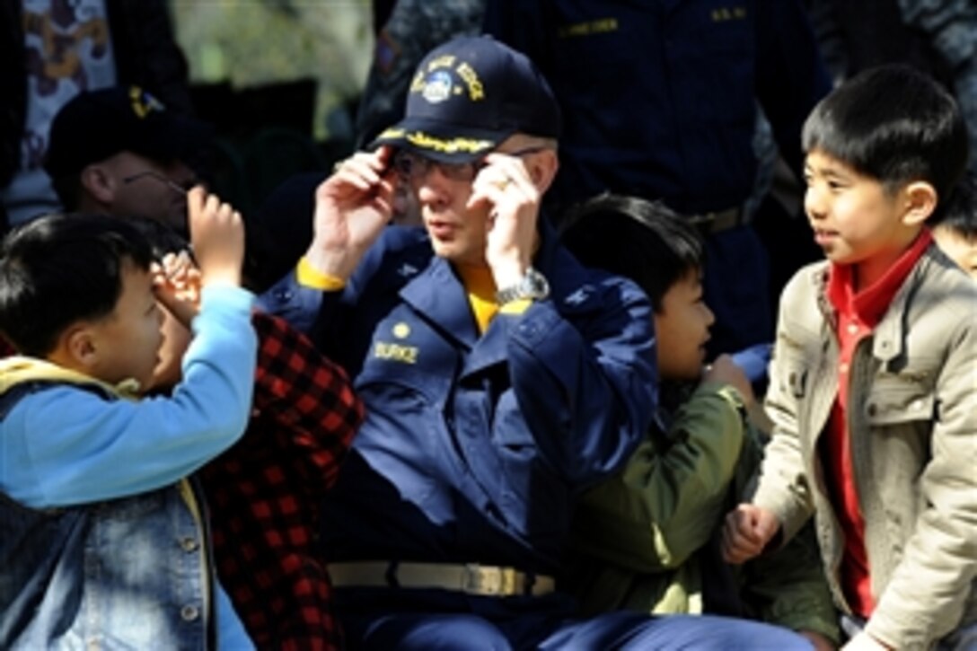 U.S. Navy Capt. Thom W. Burke shares his glasses with a child at the Hee-Rak-Won Orphanage during a community service project in Busan, Republic of Korea, March 15, 2009. Burke is commanding officer of the amphibious command ship USS Blue Ridge.