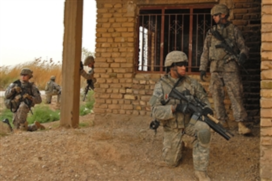 U.S. Army Sgt. Oshea Washington, kneeling right, and other soldiers pull security during a patrol in Al-Faris, southwest of Tarmiyah, Iraq, March 13, 2009. The soldiers are assigned to Company C, 1st Battalion, 111th Infantry Regiment, 56th Stryker Brigade Combat Team.