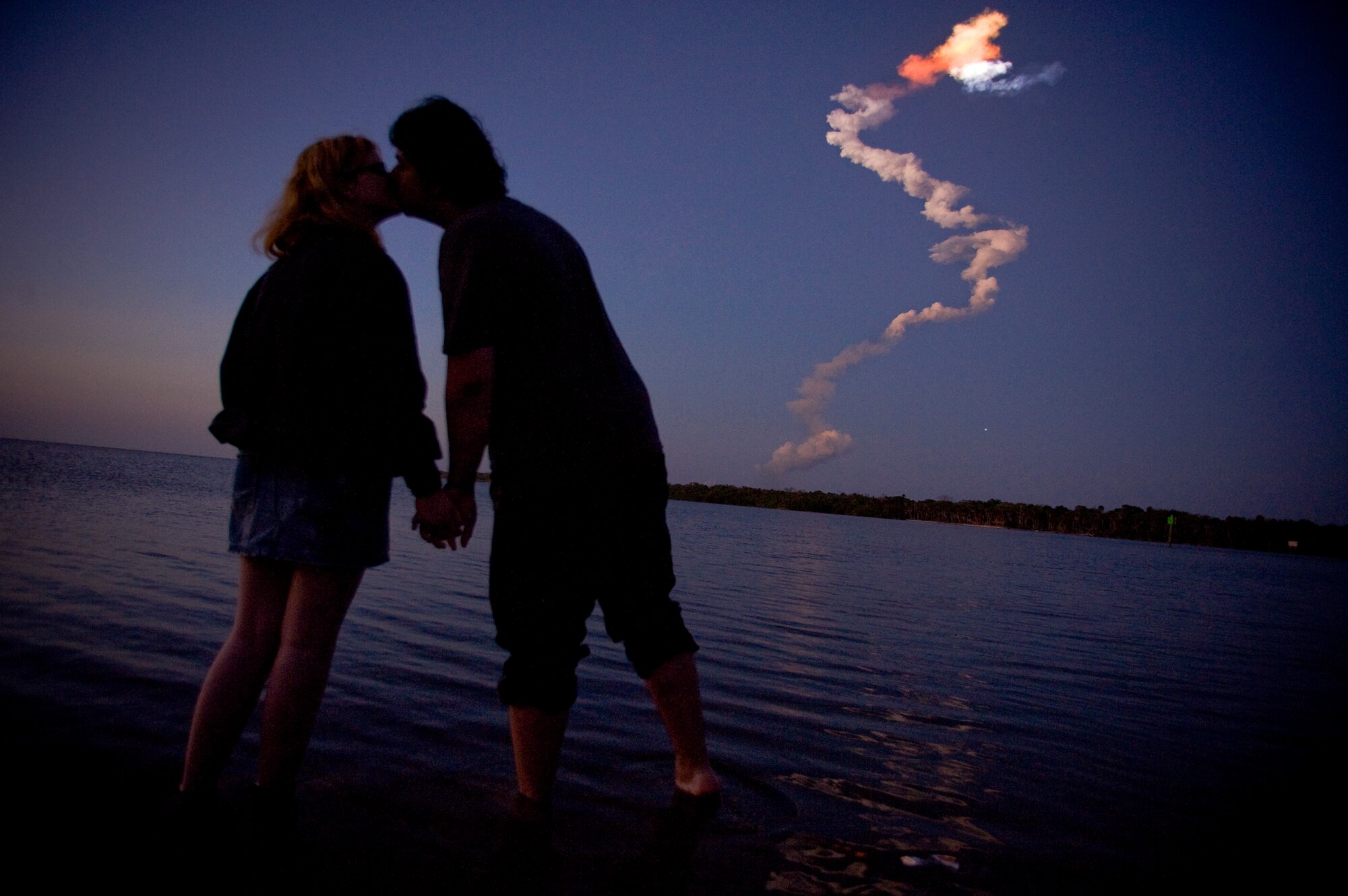 A young couple, Joe Hennessy and Caitlin Dullaghan, share a kiss in the Indian River as the space shuttle orbiter disappears from the horizon, March 16, Cape Canaveral, Fla.
(U.S. Air Force photo by/Staff Sgt. Bennie J. Davis III)