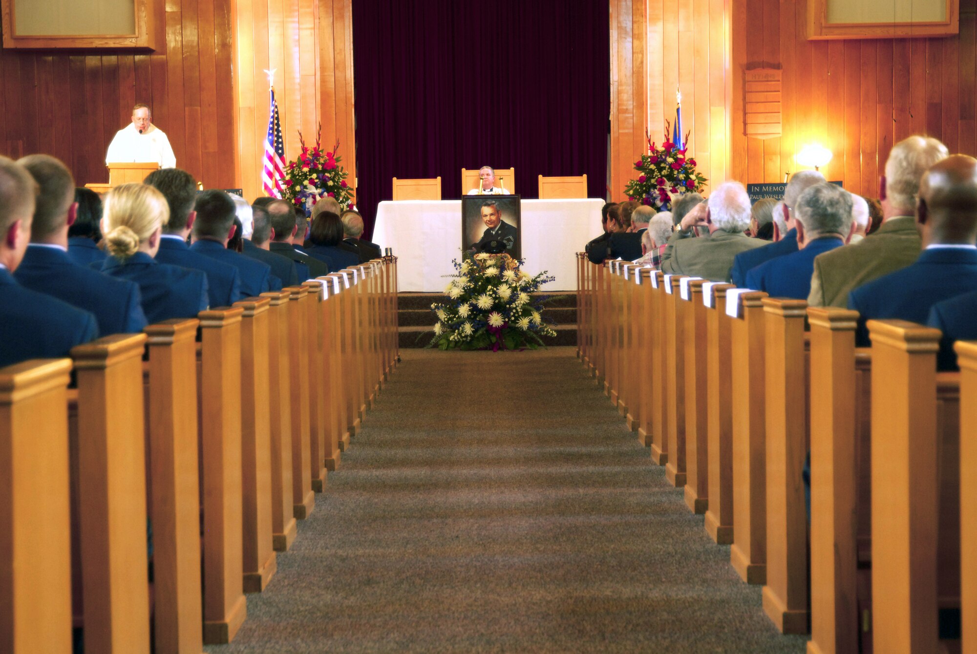 The centerpiece of the memorial service for the first Chief Master Sgt. of the Air Force, Paul W. Airey, rests in the center of the base chapel sanctuary at Tyndall Air Force Base, Fla., March 16. In front of the painted portrait of the Chief rested a solitary service cap facing forward to the audience. More than 500 people were in attendance for the memorial service. (U.S. Air Force photo/Susan Trahan) 
